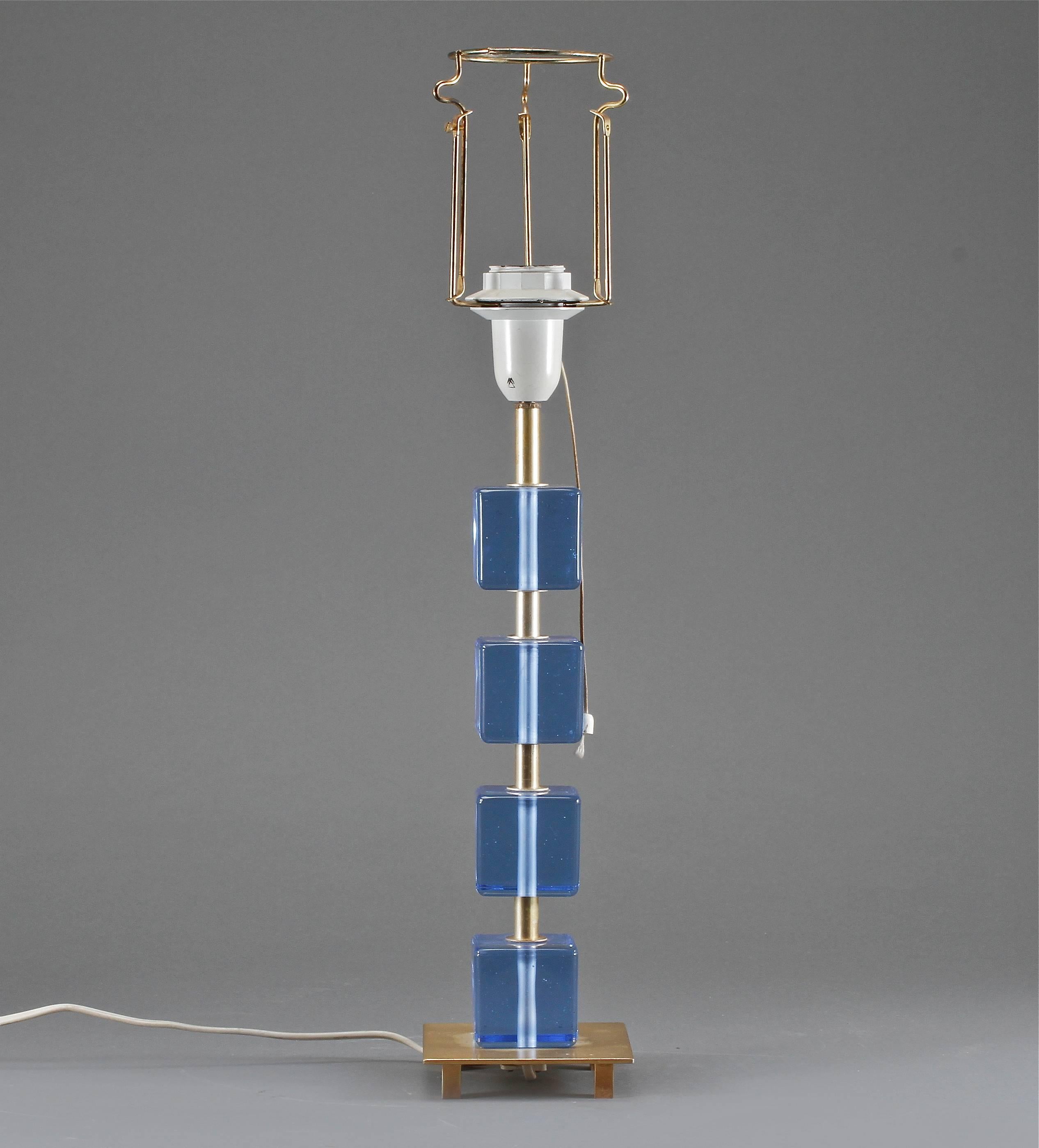 A table lamp made by Malmo Mettalyarufabrik AB, Sweden, circa 1960s.
Blue glass and brass. Measures: H 26"; base H 15" without socket. Brass base 4.25" x 4.25"; glass cubes 2.25" x 2.25".
Existing wiring. Rewiring