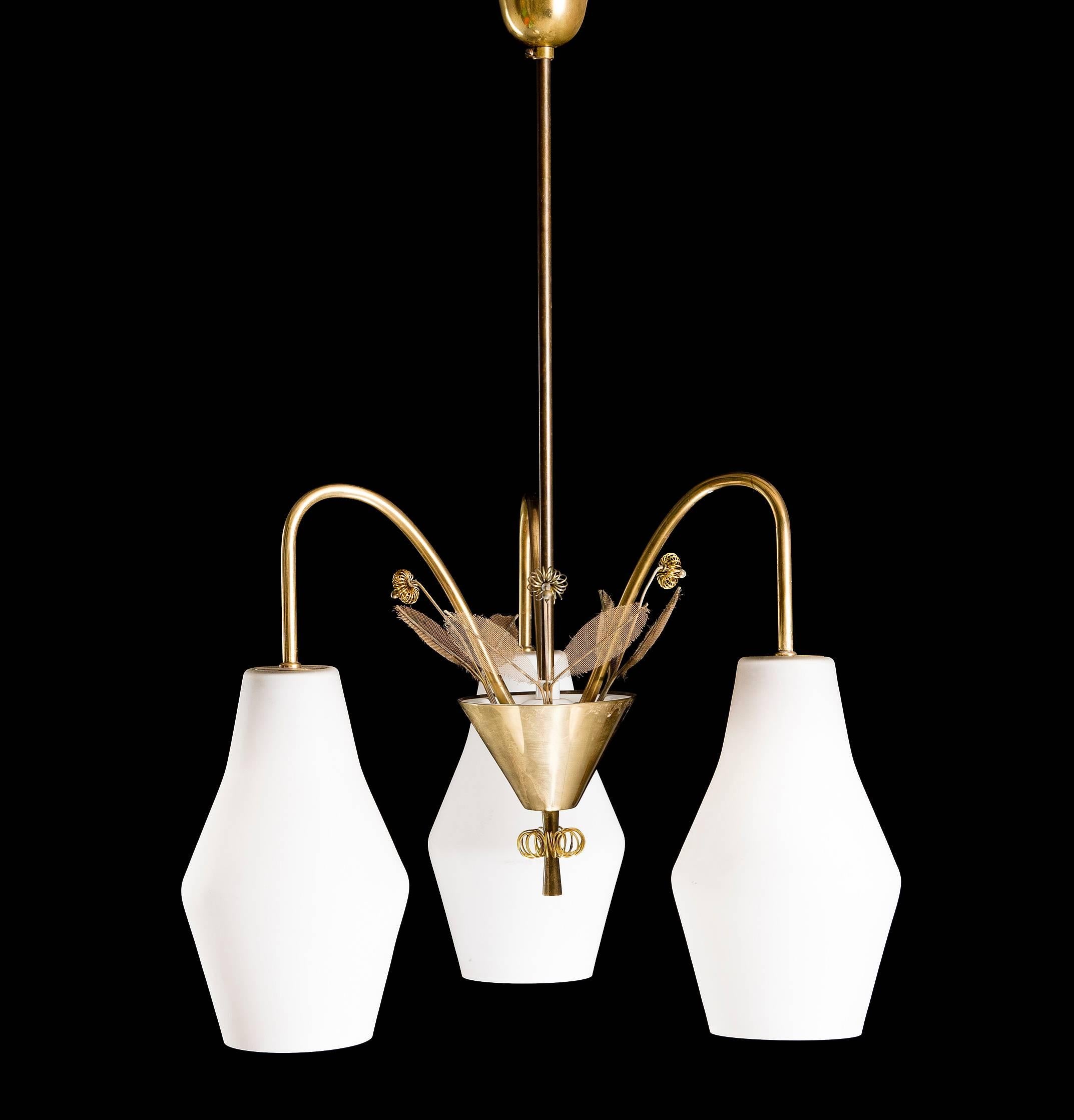 A pair of chandeliers designed by Paavo Tynell, model K1-9/L, Idman, Finland, 1950s. Marked by manufacturer. Existing wiring, we do not guaranty functionality, rewiring available upon request. Can be sold individually .
 