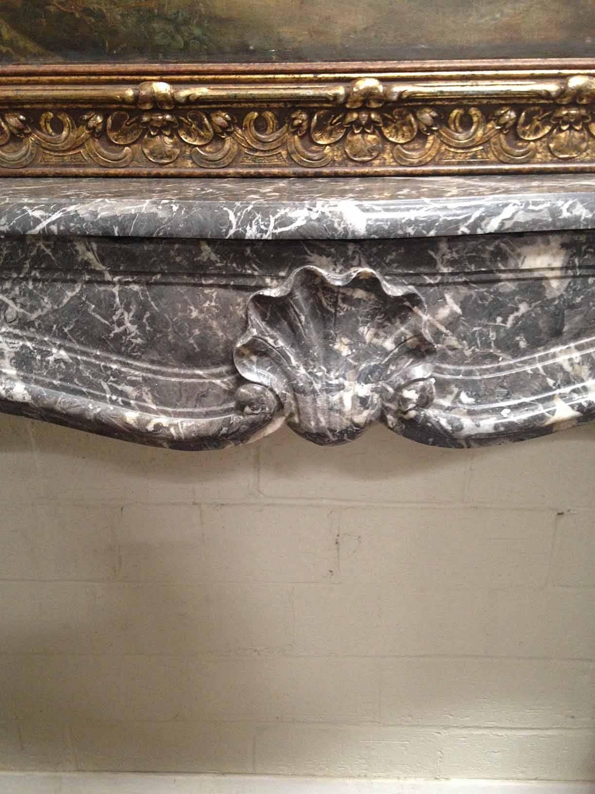 This handsome French antique marble mantel features subtle carvings with a shell design and great movement. A smart look for your study or living area.

 Origin: France,

circa 1880. 

Measurements: 53 1/4