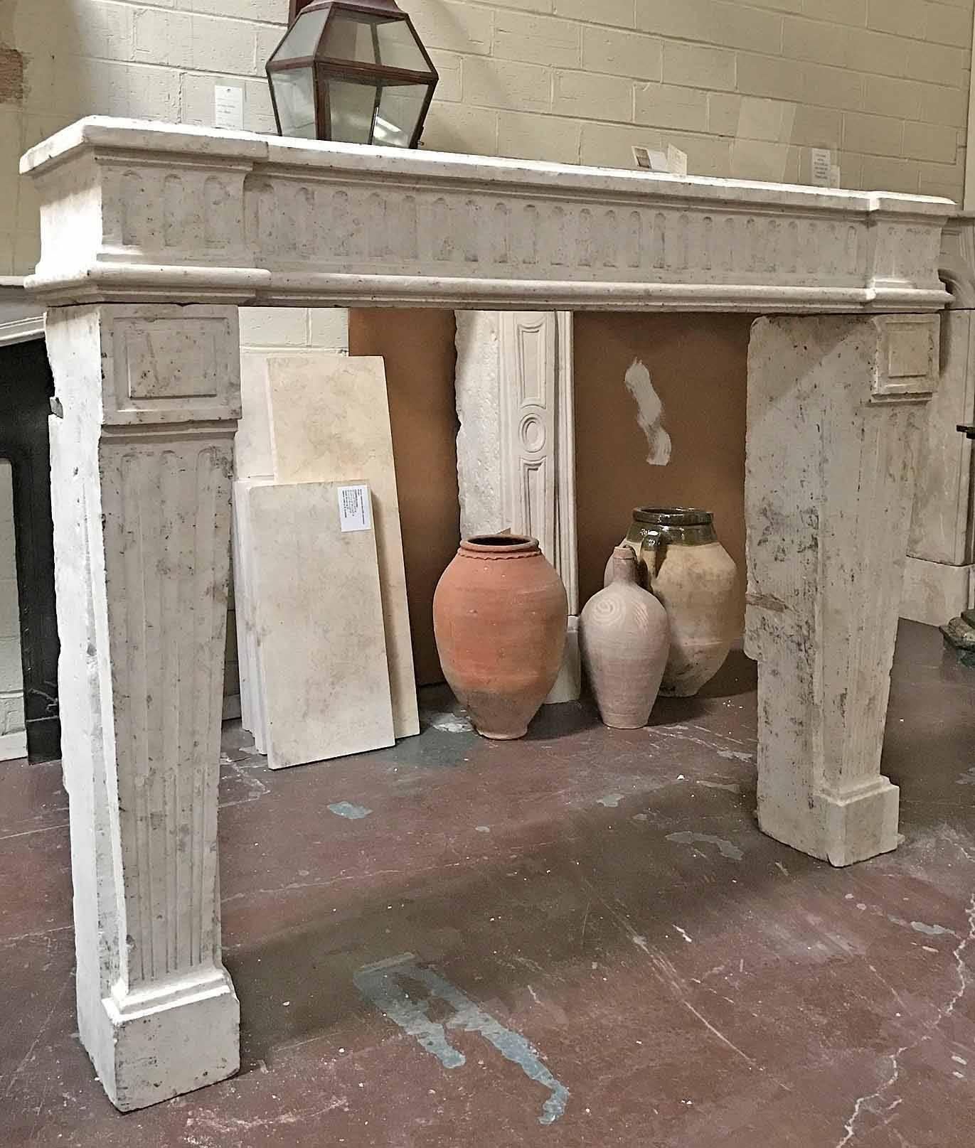 This Louis XV antique limestone mantel features fluted leg and lintel, a very smart looking piece! Origin: France, circa 1850. Measurements: 58 3/4