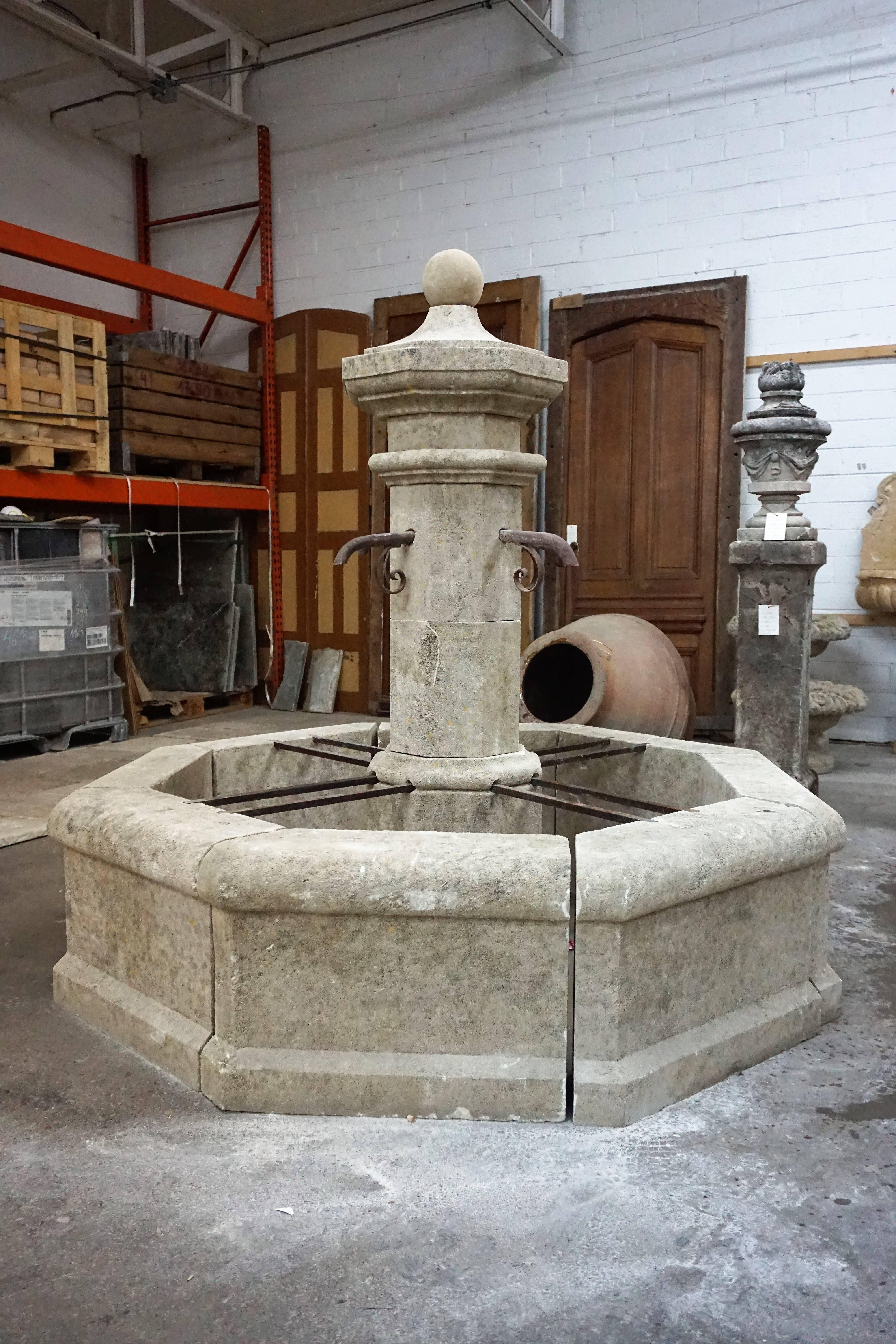 Here we offer a hand-carved limestone central fountain with four iron downspouts. This fountain is a classical French design from an antique village fountain reclaimed outside Montpellier, France. The acoustics from this fountain will fill the air