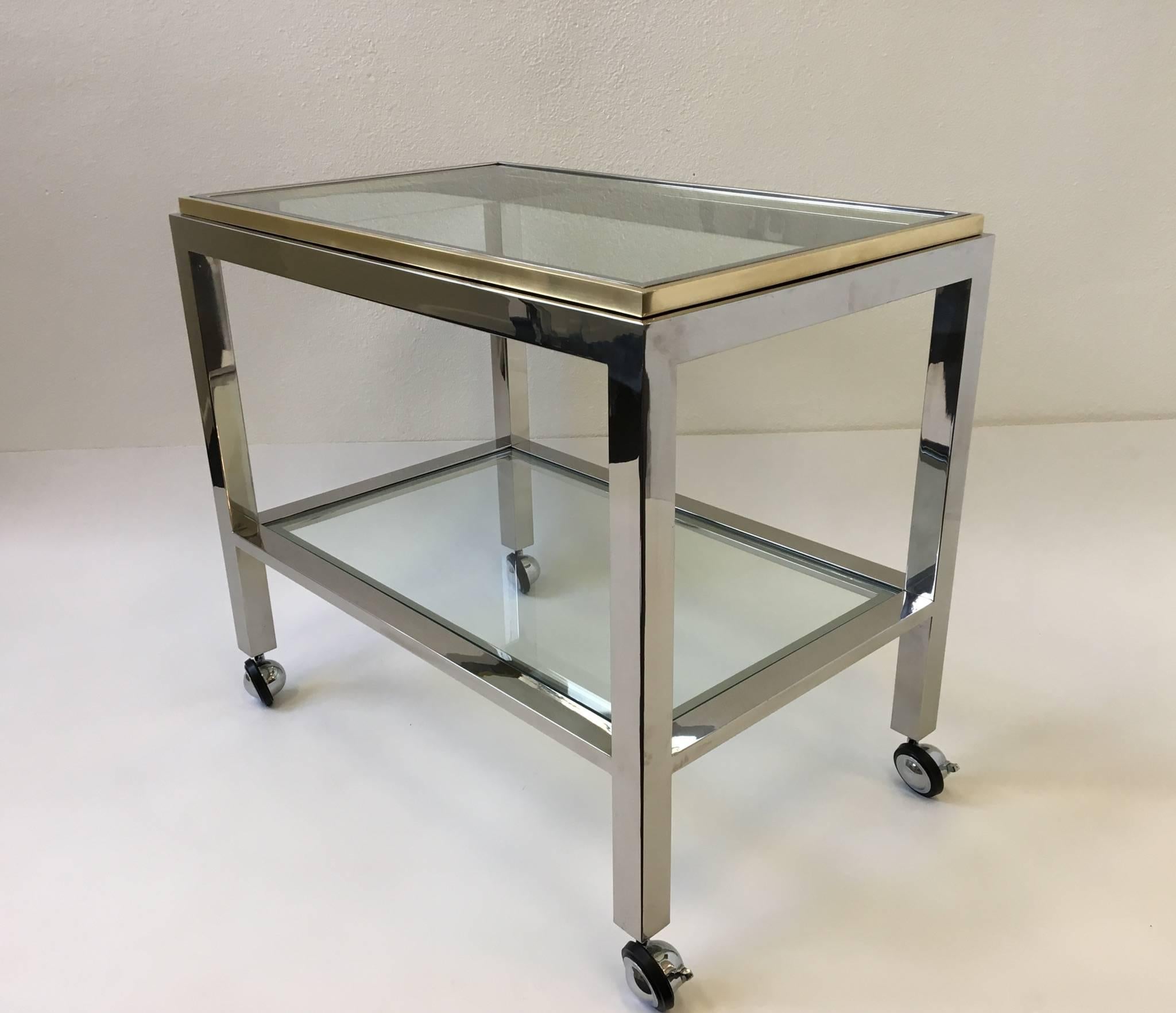 A glamorous polished chrome and brass with glass inserts Italian bar cart designed in the 1970s by Renato Zevi for Zevi & C. 
Dimension: 27.5