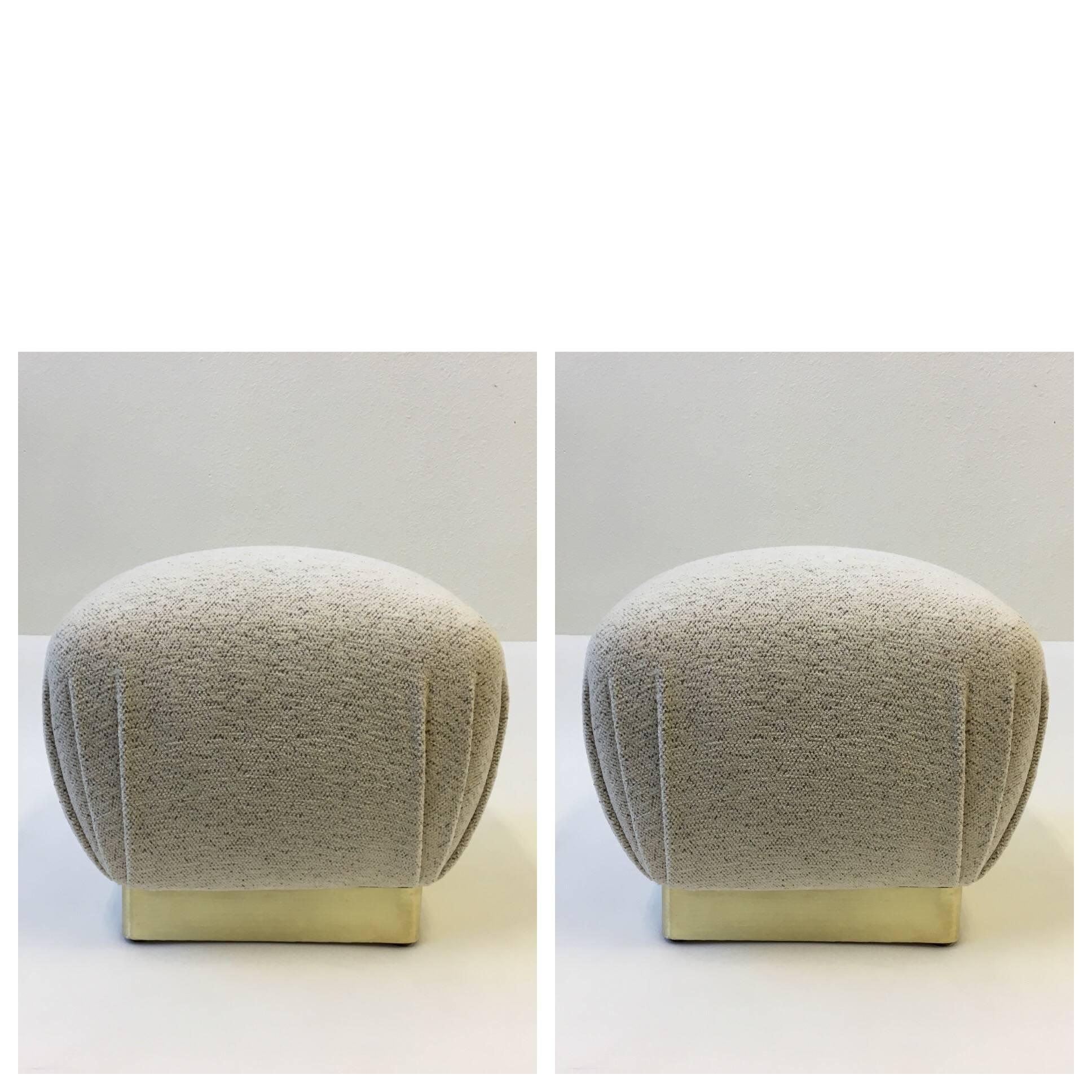 A pair of glamorous poufs designed in 1970s by Marge Carson. Newly recovered in a off-white with hints of light brown spots Chanel fabric, the base I'd wood covered with a satin brass band. One of the poufs retains a label.
Dimensions: 17