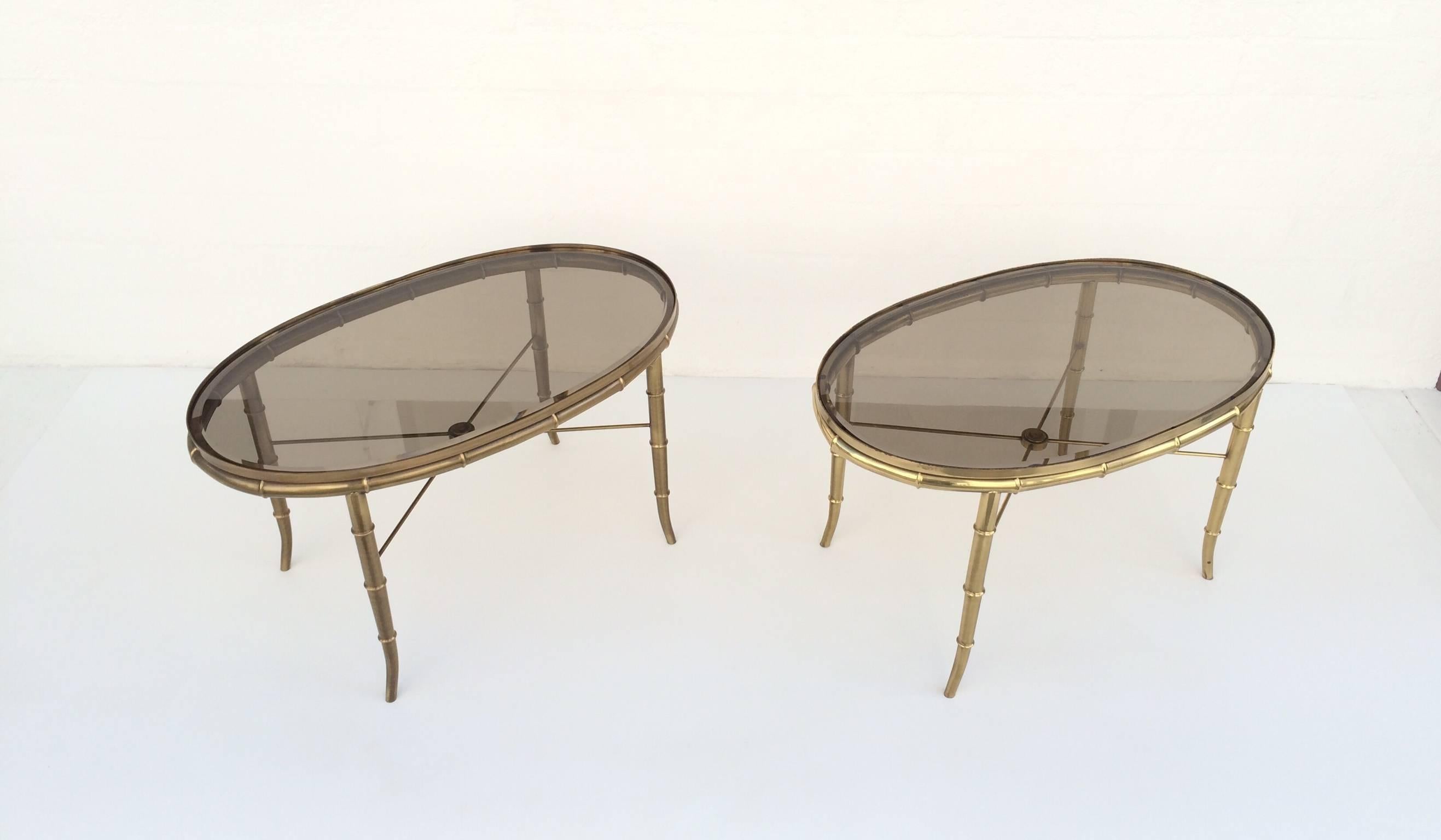 A pair of  occasional tables by Mastercraft. 
These tables consist of the aged brass faux bamboo frames,  with new 1/2