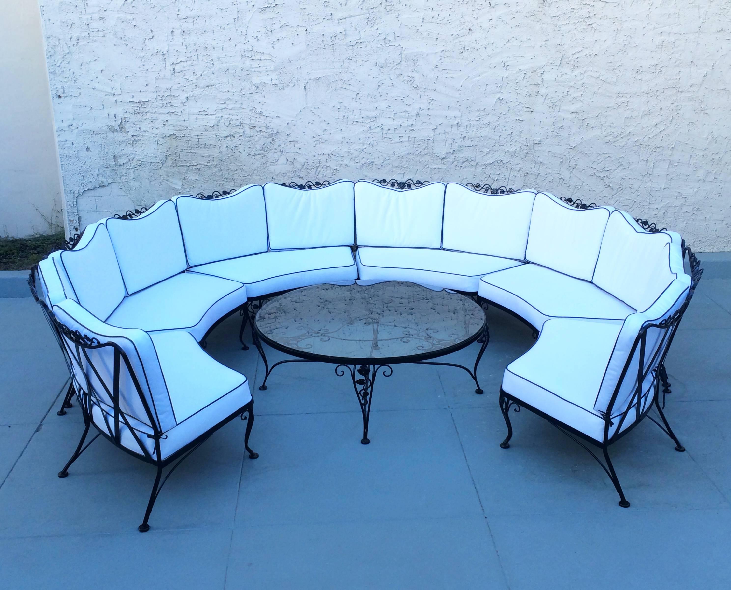 This beautiful six section sectional sofa designed by Russell Woodard is wrought iron that is newly powder-coated in black and has all new seat and back cushions upholster in a white marine sunbrella with black vinyl piping. 
 Included are new
