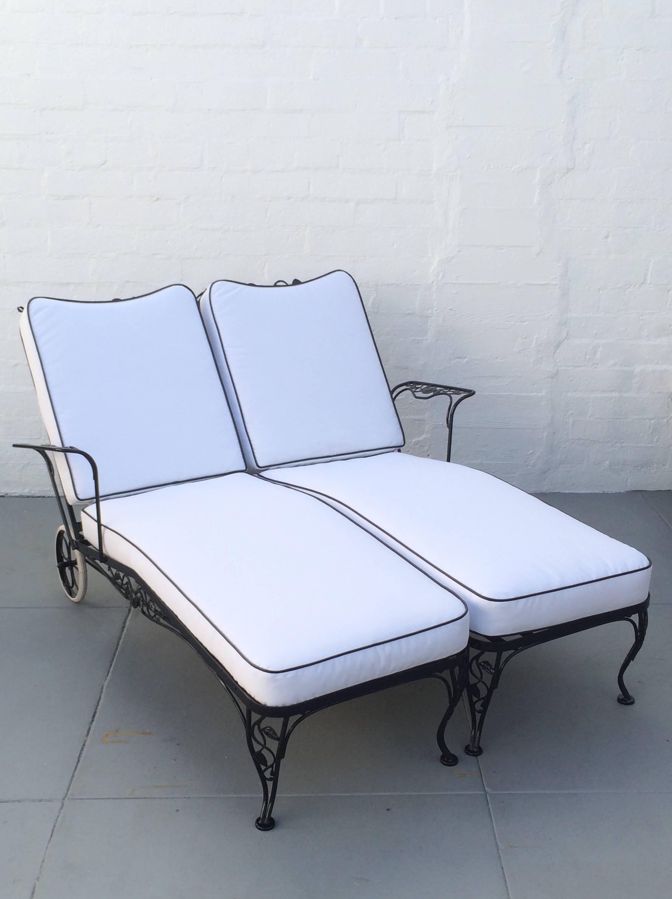 Newly powder-coated in black 1950s wrought iron lounge chaise for two designed by Russell Woodard. 
Designed to be side by side, but can be moved apart. 
Each lounge has an adjustable back for maximum comfort. 
All new cushions covered in a white