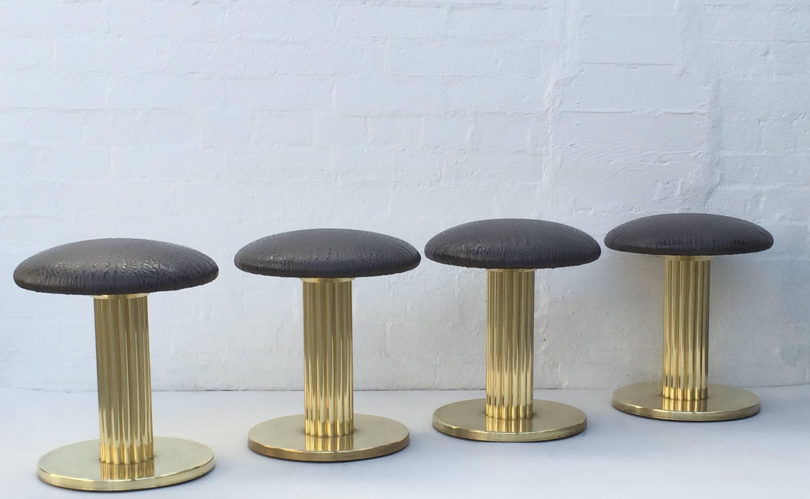 This sexy set of four brass and leather swivel stools were design in the 1980s by Design For Leisure Ltd. The bottom base is a brush brass and the rest is polished brass. The seats are newly reupholstered in a gray embossed crocodile leather.