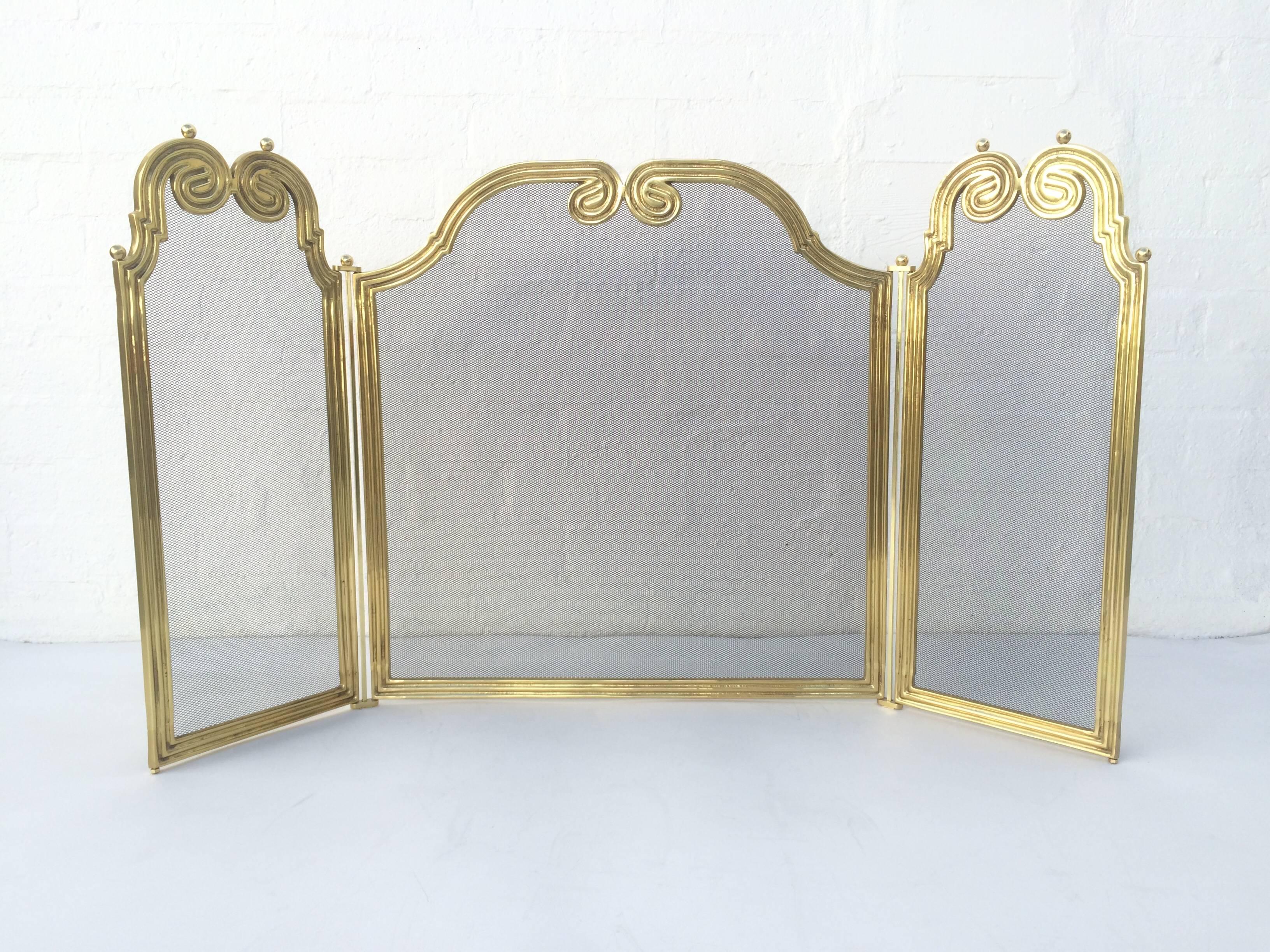 An elegant cast solid brass fireplace screen, 
circa 1970s.
The screen measures 55 inches from end to end when it's opened all the way up. Each end section is 12 1/2 inches wide with the middle section measuring 31 inches wide. 
Height is 30.75