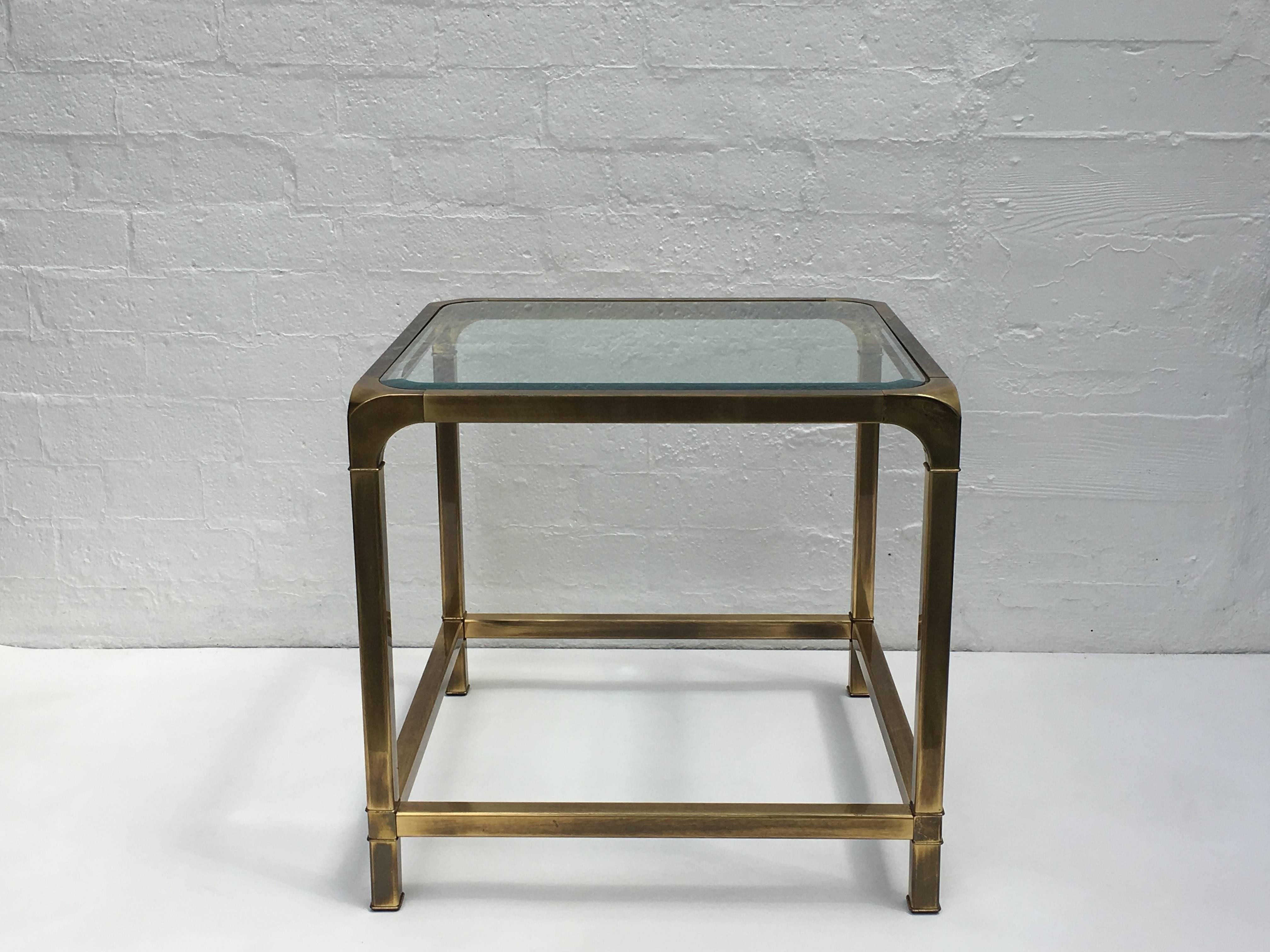 A beautiful aged brass end table with a beveled glass top insert. Design by Mastercraft in the 1970s