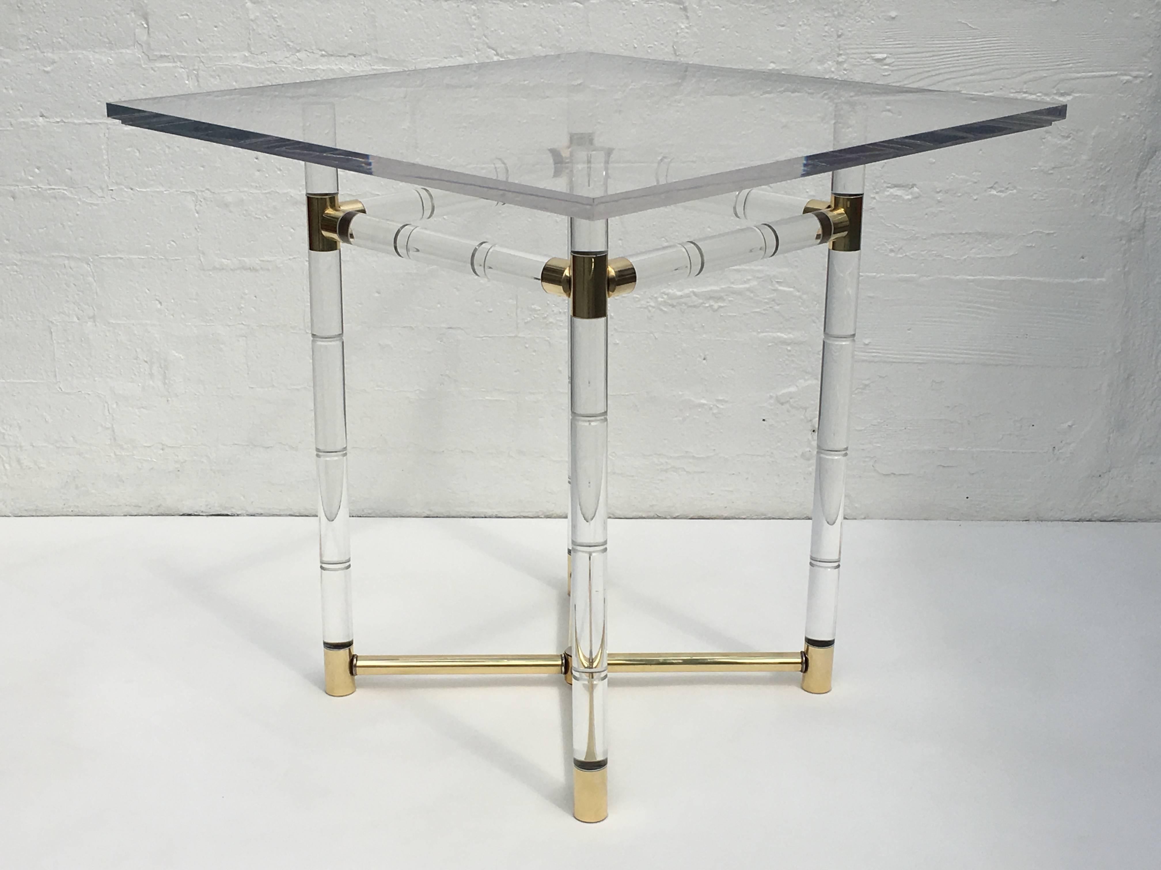 A glamorous brass and acrylic center table designed by Charles Hollis Jones in the 1960s. This is part of his