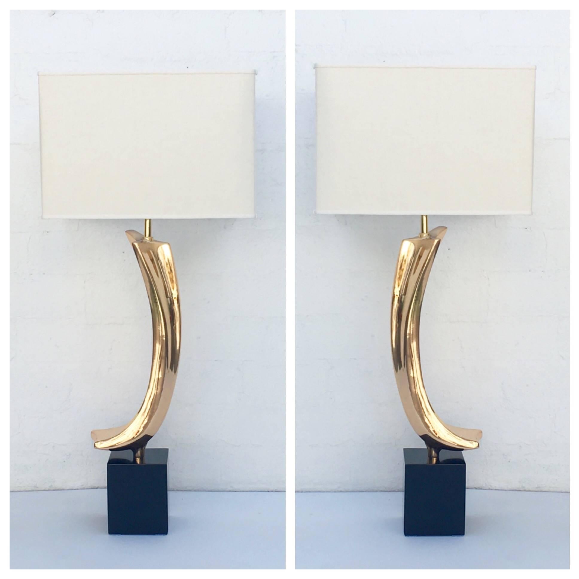 A very attractive pair of polished brass tables lamps. 
Newly re-plated in brass and newly powder-coated black bases. 
Newly re-wired with new brass hardware and new rayon braided cord. 
The new shades are vanilla colored linen. 
Designed by