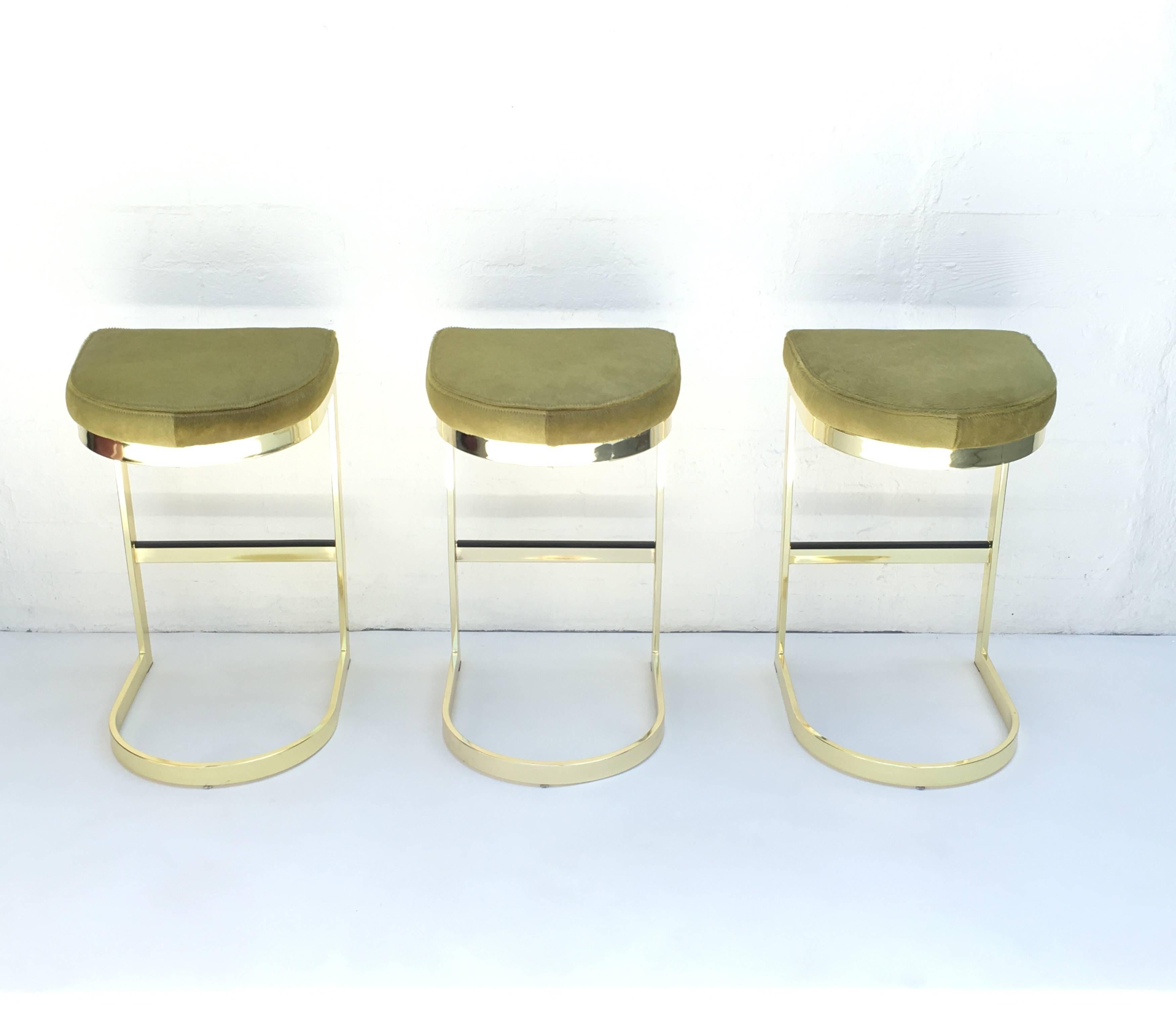 American Set of Three Polished Brass and Pony Hide Barstools by Milo Baughman 