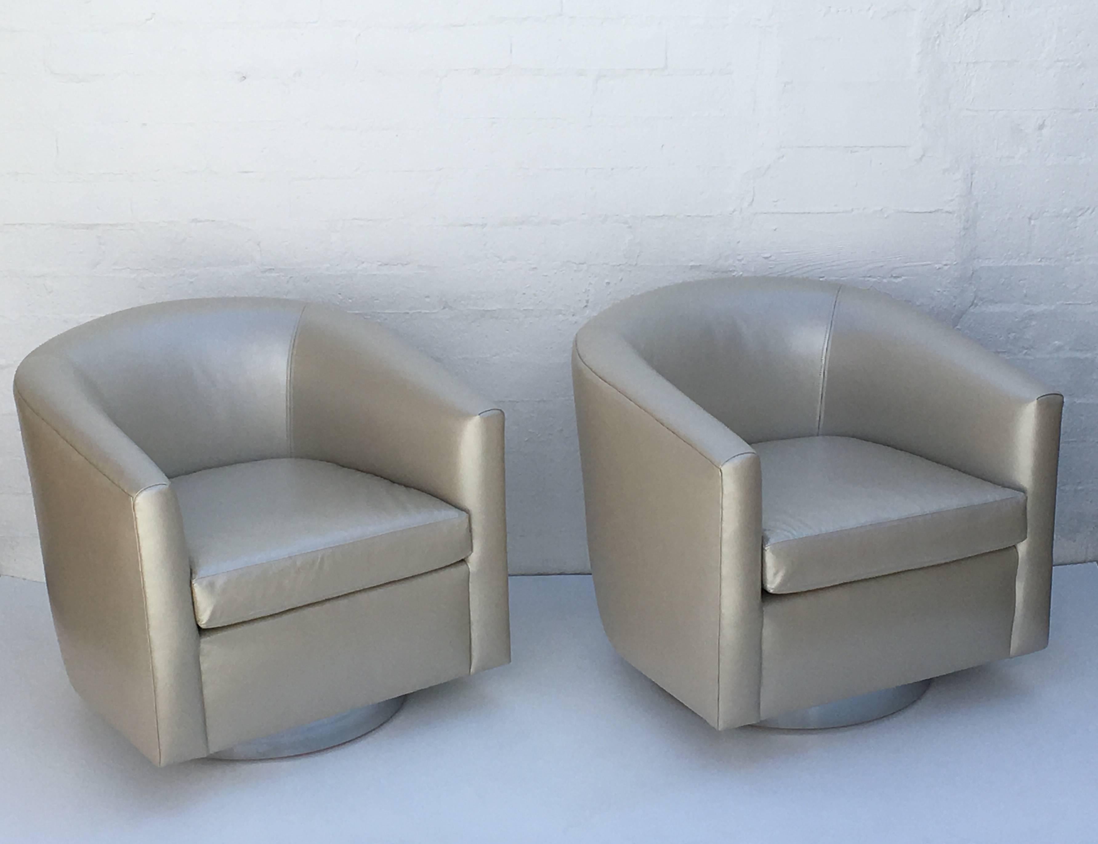 A pair of chrome and leather barrel swivel chair by Martin Brattrud for Steve Chase. This came out of a Steve Chase estate. Newly reupholstered in a soft pearl color leather.