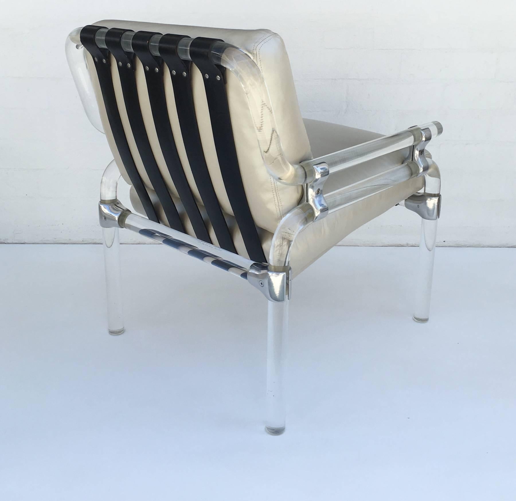 A glamorous acrylic and leather lounge chair designed by Jeff Messerschmidt in 1974 from the 1000 pipe line series chair #61. 
Constructed of thick acrylic pipe connected by polished aluminum brackets, thick black leather straps hold the newl