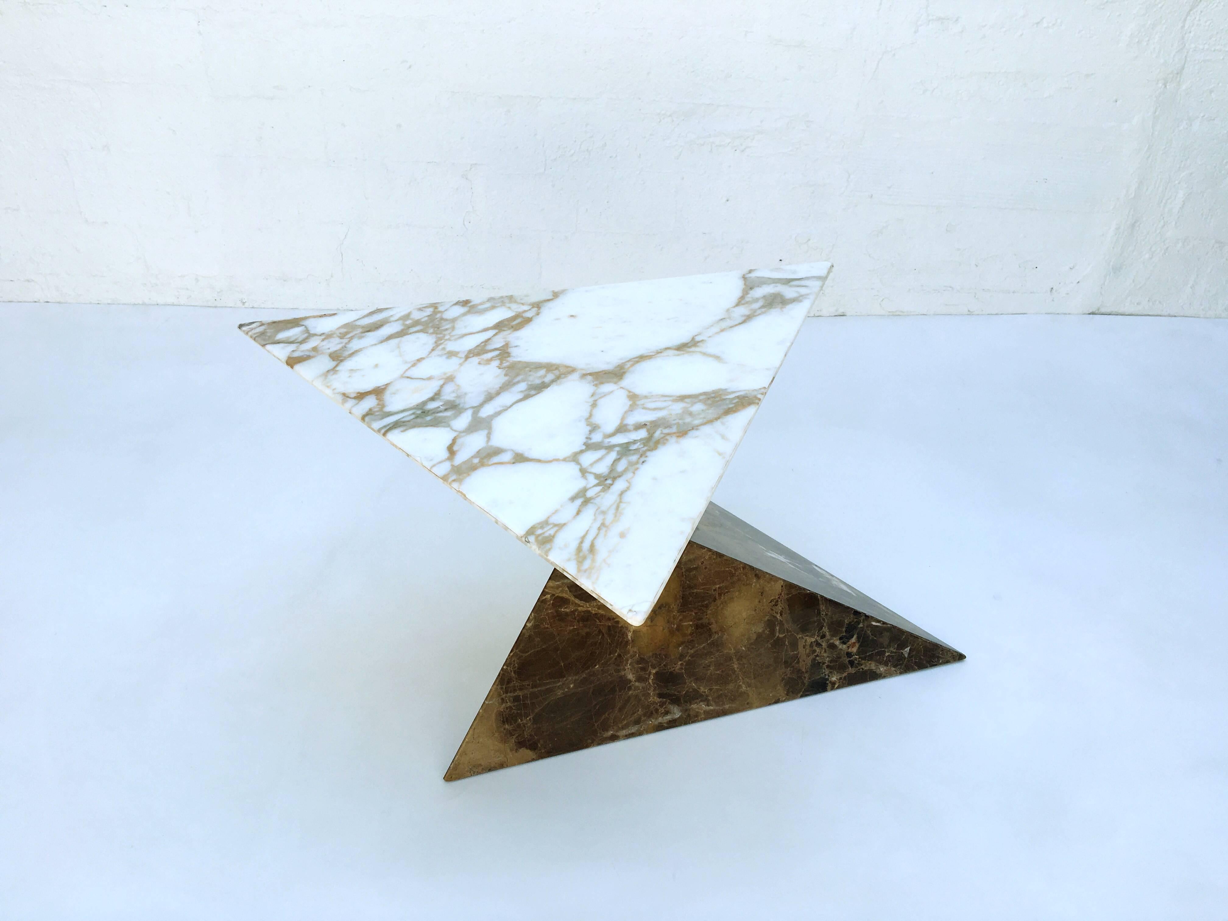 An amazing balancing marble pyramids occasional table from the 1960s.
The top pyramid is Carrara marble and the bottom one is beautiful brown marble. 
This can be used as a table or as a sculpture up on a pedestal.
This reminds me of the tables