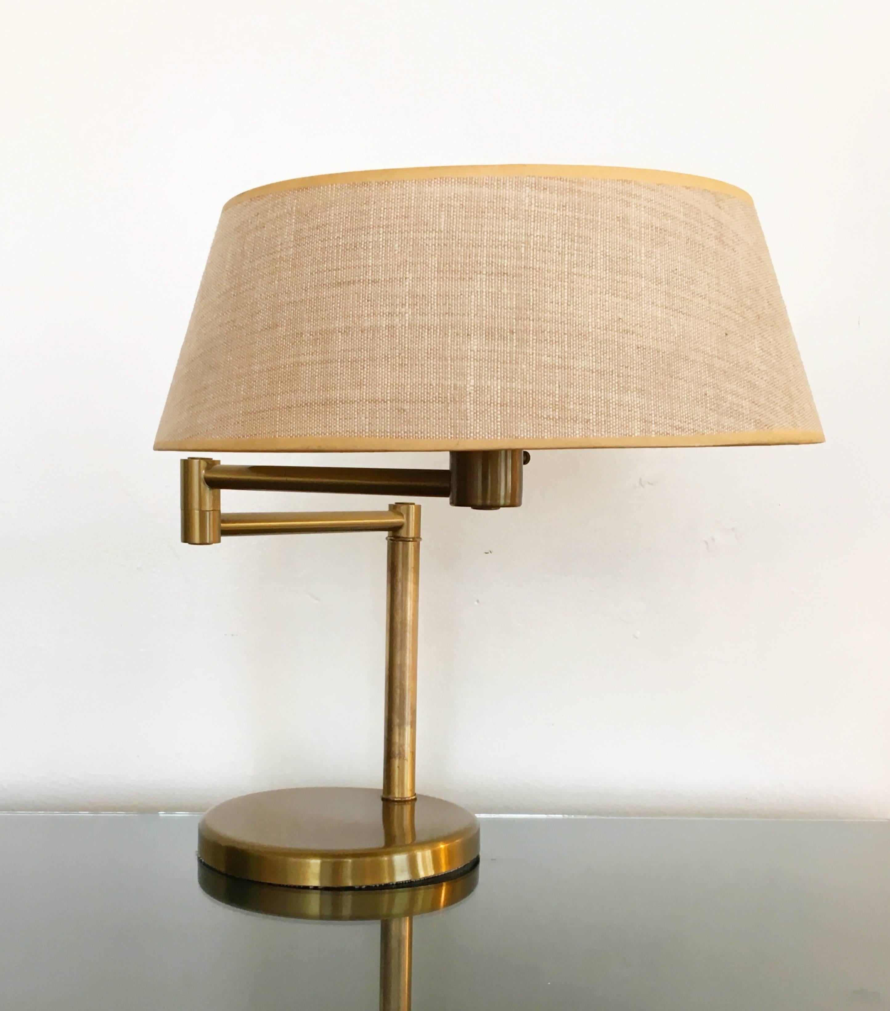 A beautiful aged brass desk or table lamp in original condition. This is a classic modern design by Walter Von Nessen in the 1960s. 
The arm is adjustable, when extended all the way it's 25