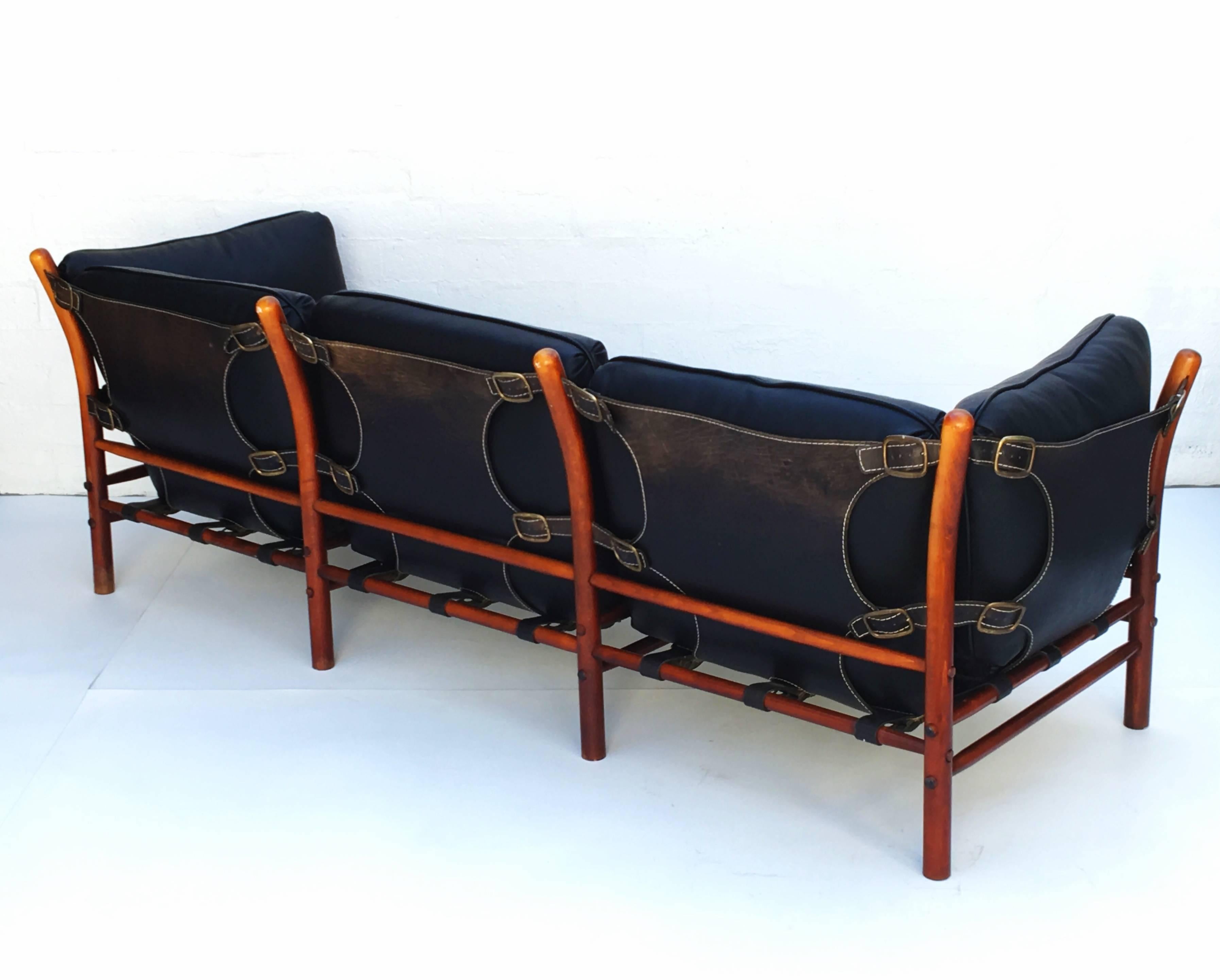 A beautiful black leather and dark beechwood design by Arne Norell AB in Aneby, Sweden.
Thick black saddle leather sling support the newly reupholstered soft black leather cushions.