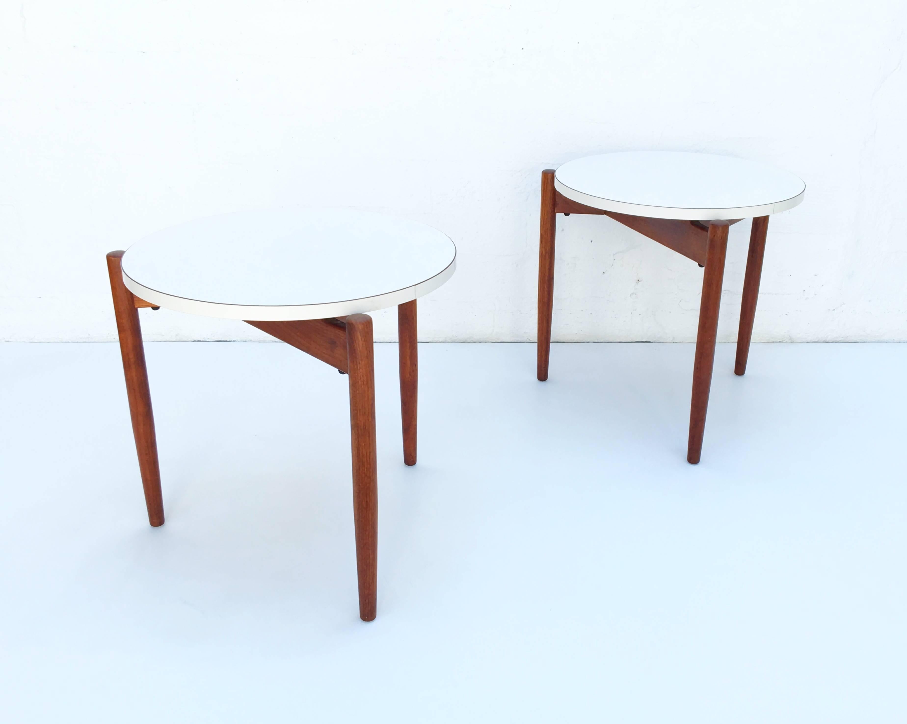 Rare pair of tripod dark walnut with white Formica tops staking side tables design by Jens Risom in the 1960s.

