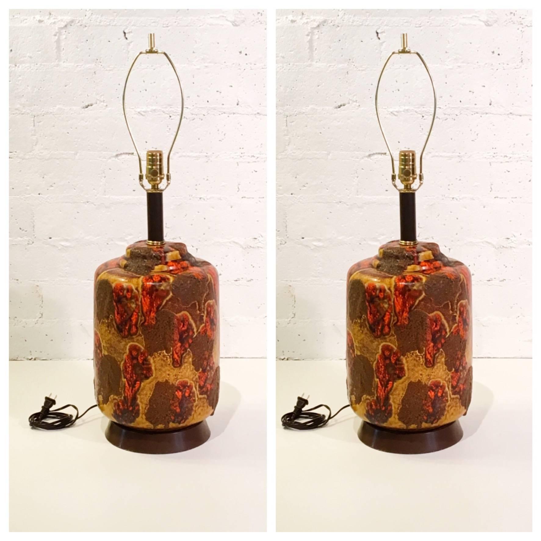 An amazing pair of 1960s ceramic table lamps with a orange, brown and mustard color volcanic drip glazed.
Newly rewired with all new brass hardware and new oatmeal color linen shades.
 
