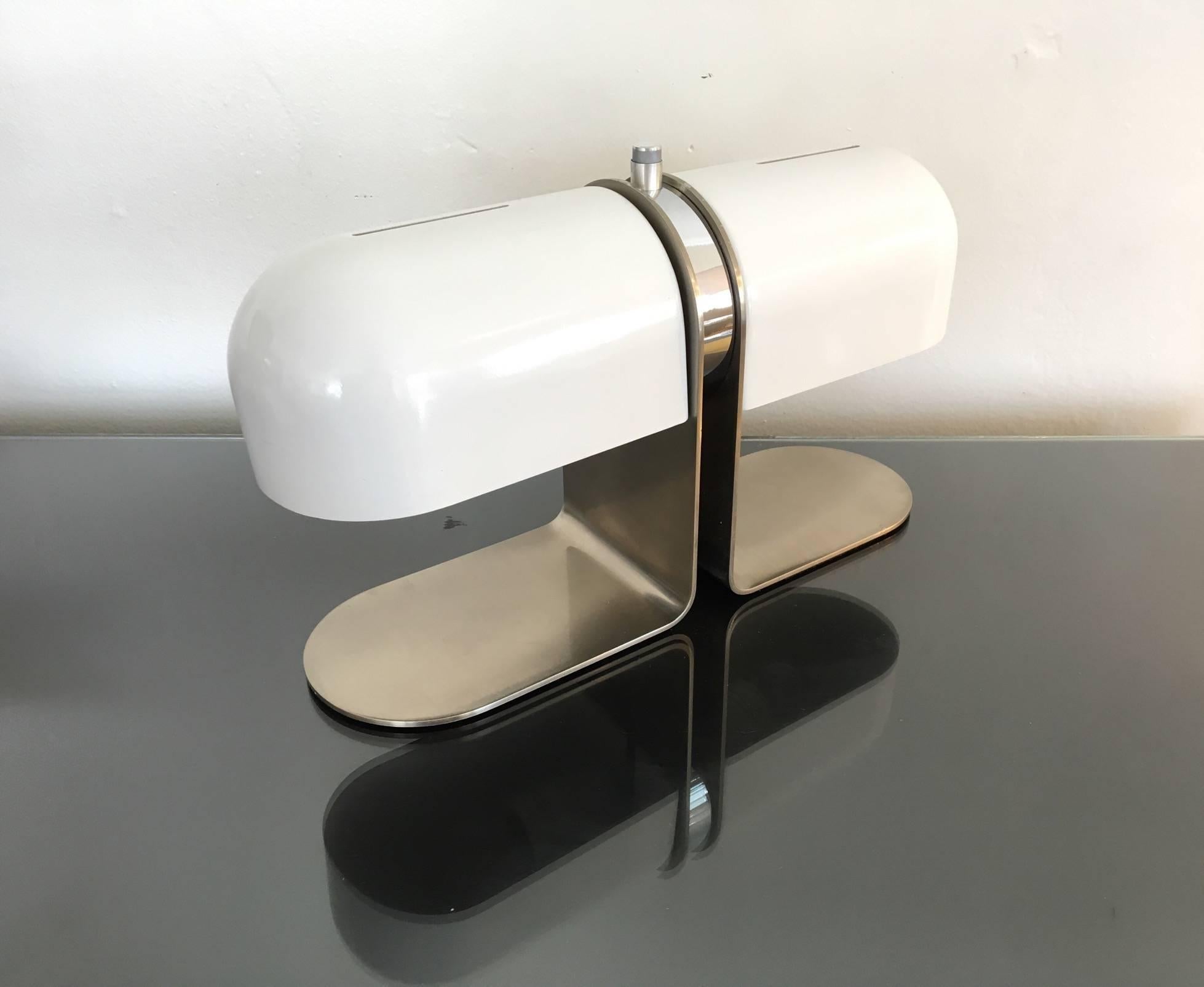 Beautiful designed double shaded desk lamp from the 1960s.
Made out of brushed stainless steel and the shades are powder coated white. 
It had a European plug. Not sure on who designed it. It has a marking, see photos.
