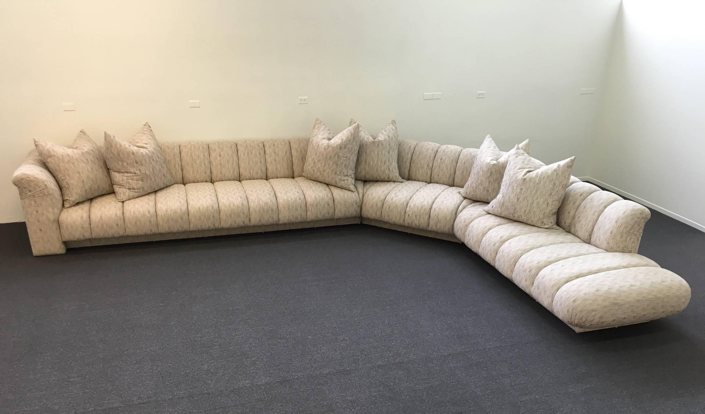 A spectacular channel tufted three-piece sectional sofa designed by Steve Chase in the 1980s. The six oversize pillows are down filled. Upholstered in a soft cotton fabric. 
Please see detail photos.