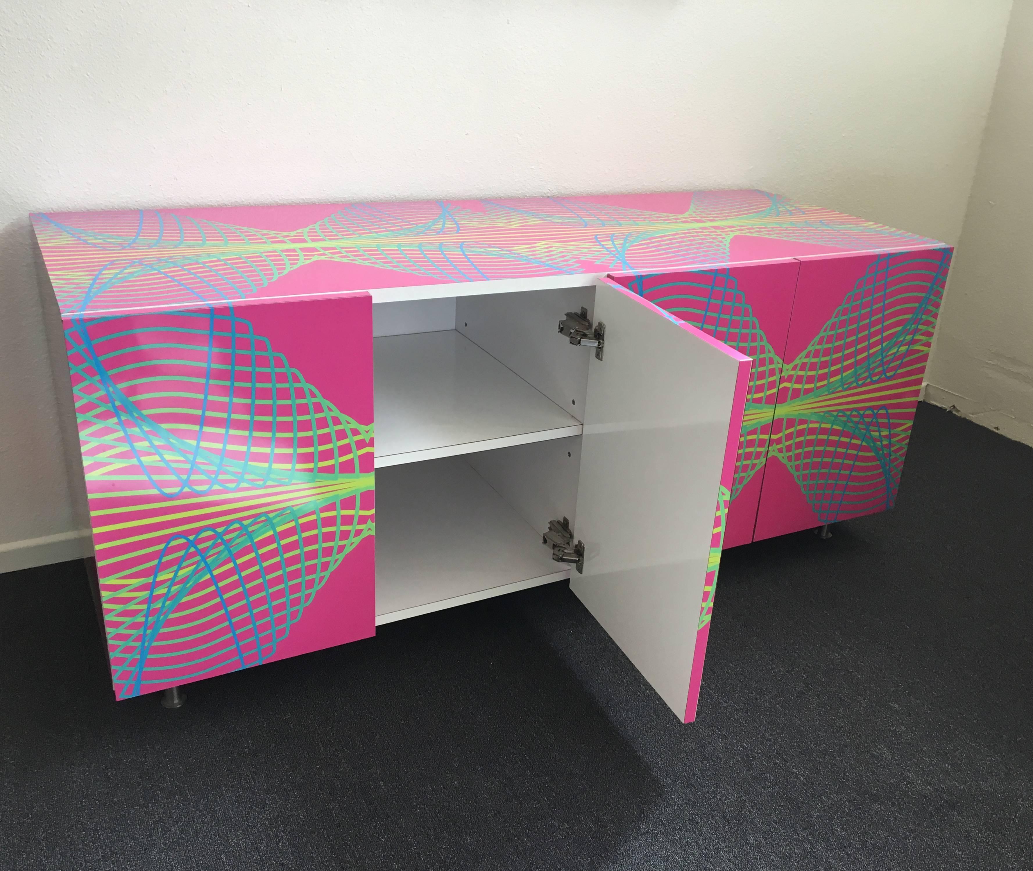 A colorful formica and brushed stainless steel legs studio cabinet by Karim Rashid. This was purchased in 2006 from a show he had at M Modern Gallery in Palm Springs. The outside is very colorful with geometric wave patern and the inside is all