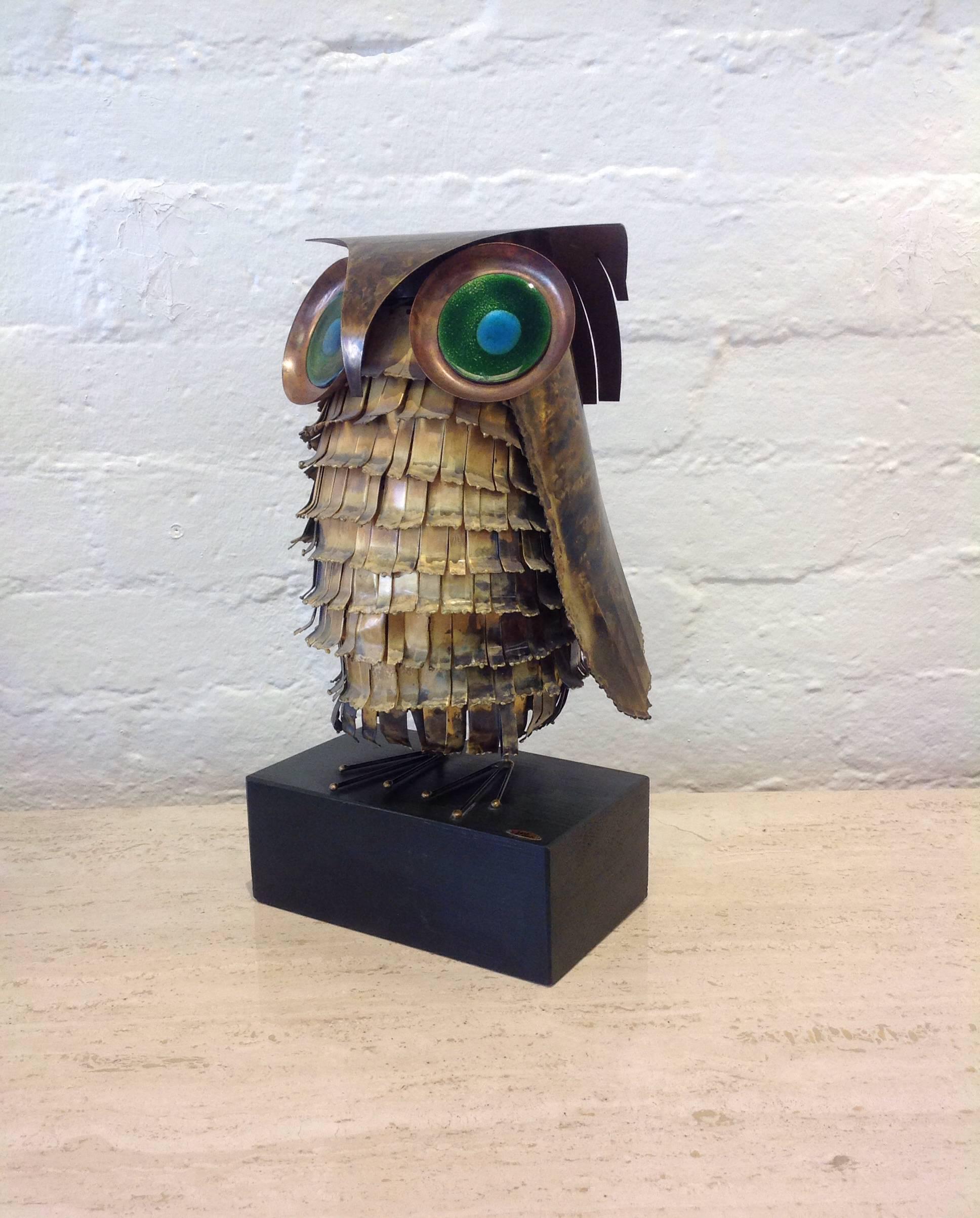 A large copper owl with green and blue enamel eyes on a black wood base.
Sign and dated 1966 by Curtis Jere.