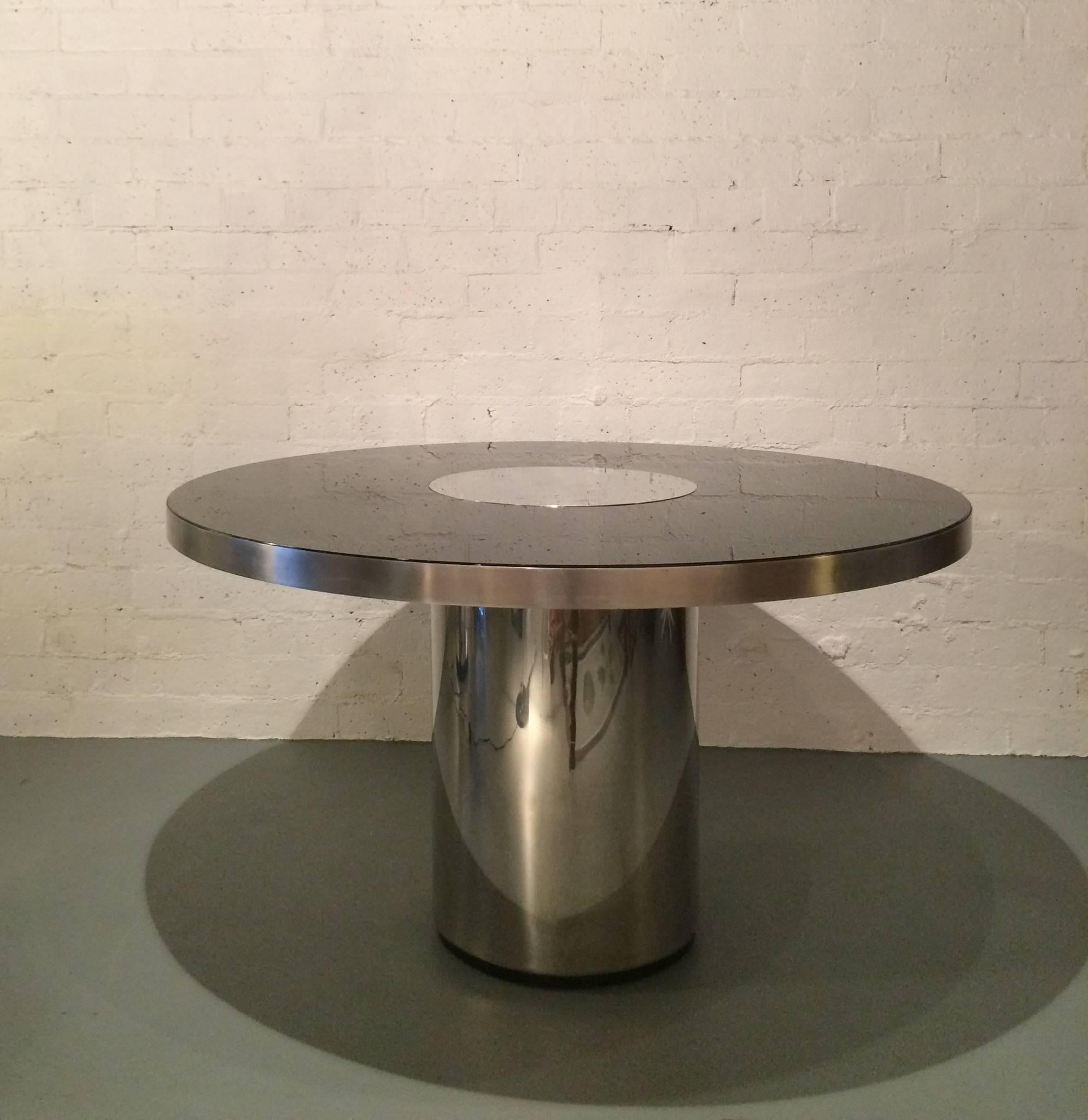 A rare glamorous polished stainless steel and smoked glass top dining table designed by Willy Rizzo in the 1970s. 
 The table has a 1/2