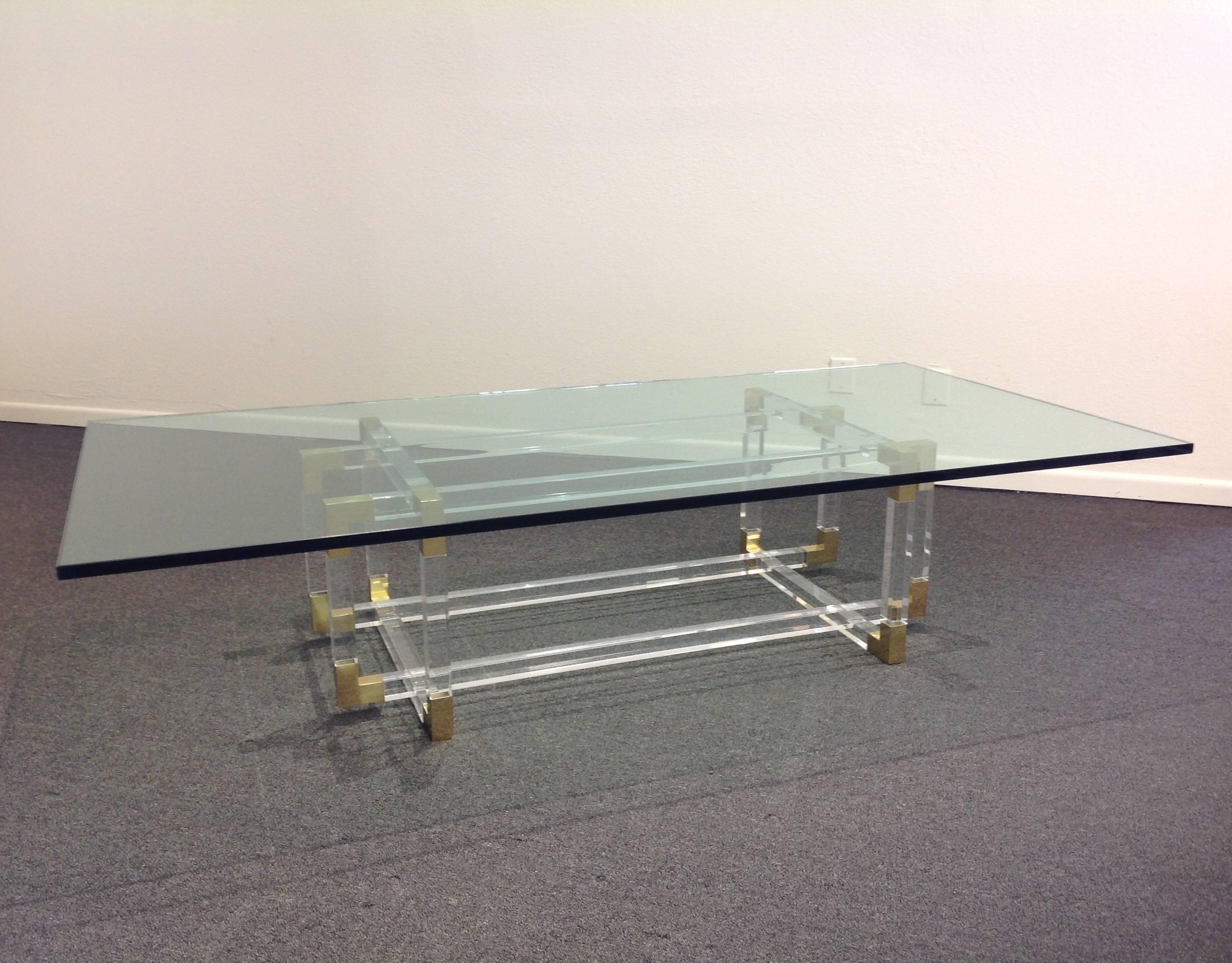 A glamorous polished acrylic and brass with thick glass top coffee table designed by Charles Hollis Jones in the 1970s.

The base has some minor wear.
Measures new: 72