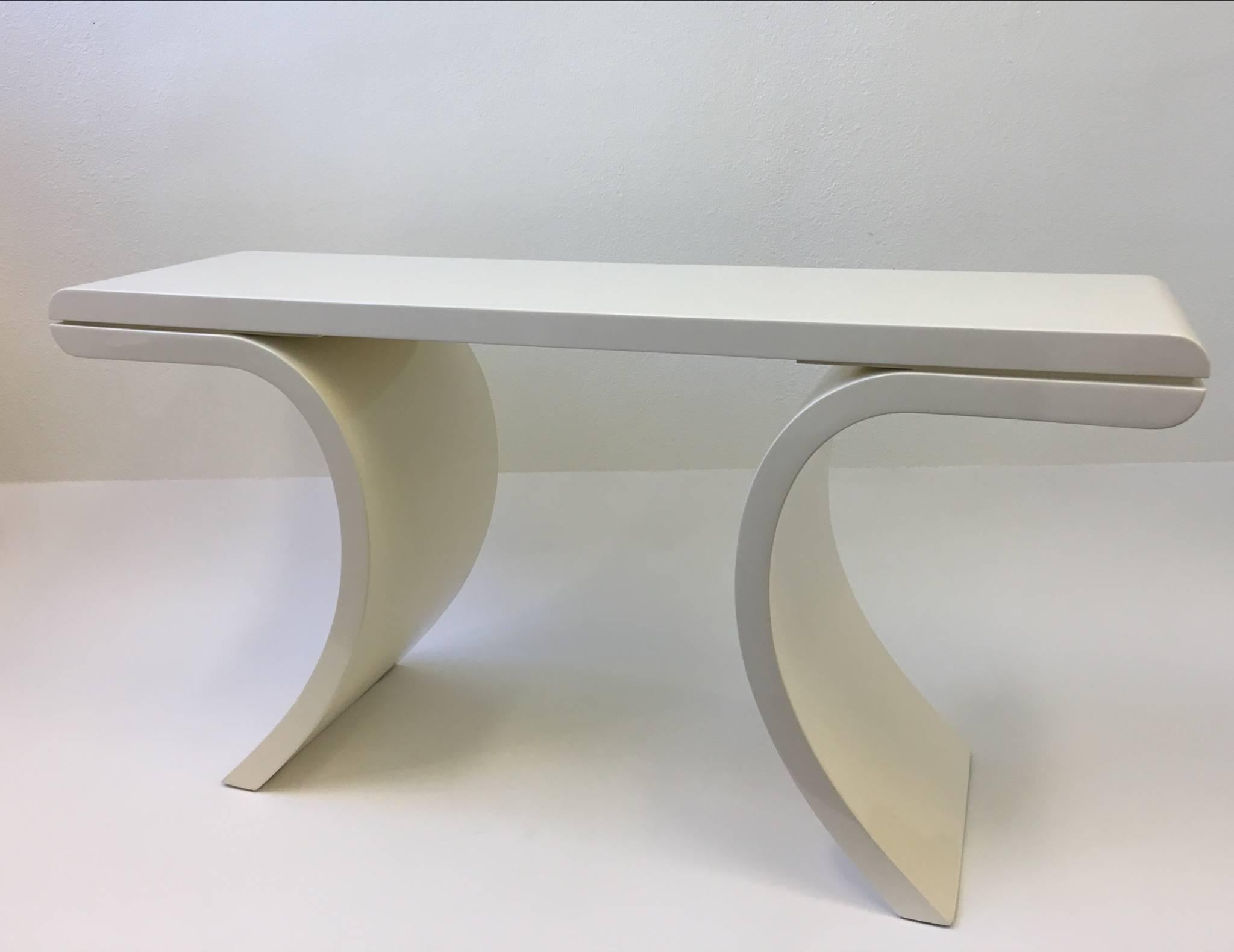 A glamorous high gloss lacquered console table in the manner of Karl Springer. This were usually covered in goatskin or lacquered. 
Newly professionally lacquered and polished in a off-white color. 

Dimensions: 28.75