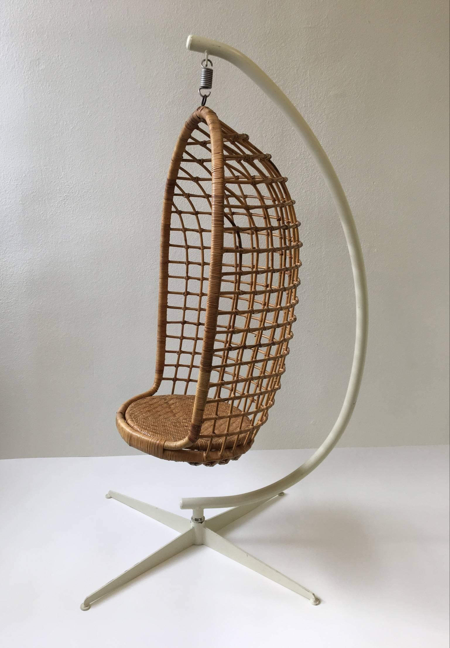 A beautiful original 1970s rattan and iron hanging chair. The chair is in original condition. The iron is painted in a cream color paint and it has some wear.