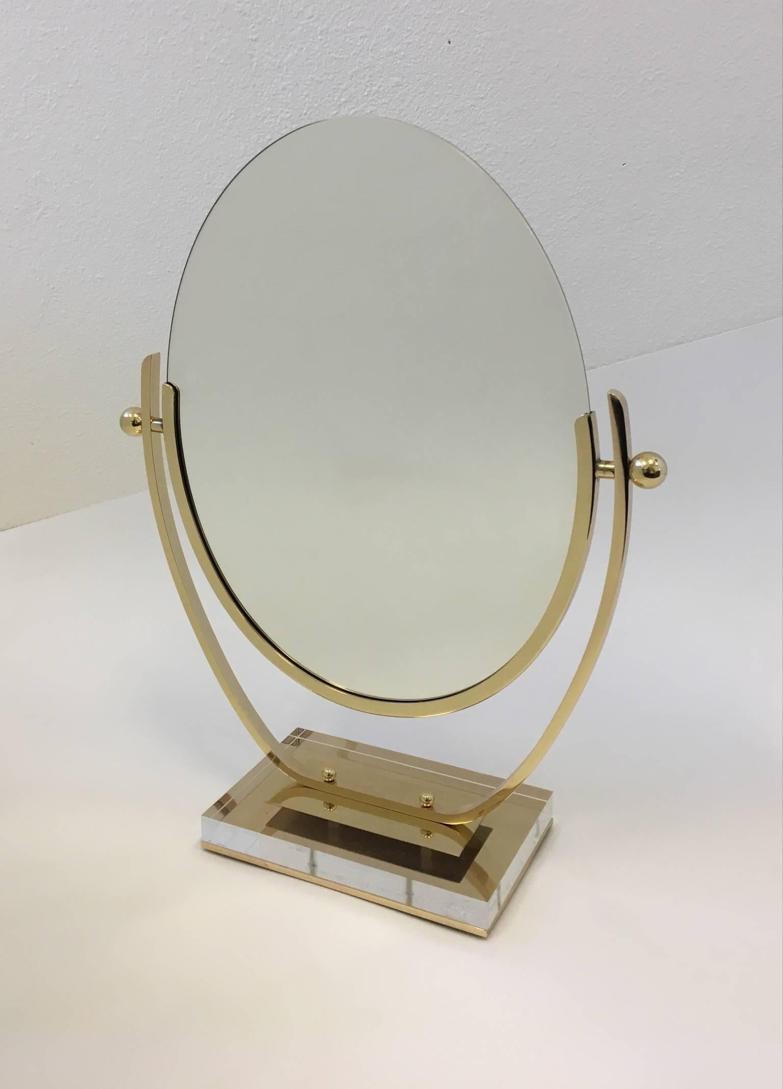 An early 1960s polished brass and acrylic vanity mirror by Charles Hollis Jones.
The back of the mirror is covered with soft olive green cowhide. 
Dimension: 18