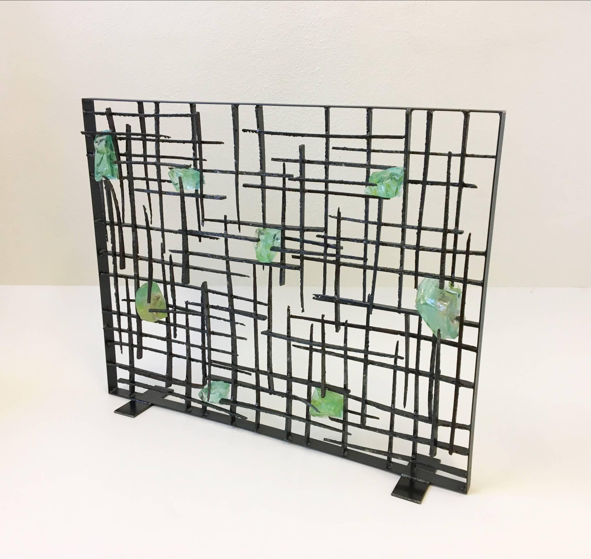 An amazing Brutalist studio fireplace screen by American Sculptor John De La Rosa. 

The screen is constructed of cut steel and clear green with some hints of yellow slag glass. (See detail photos).

Dim: 32