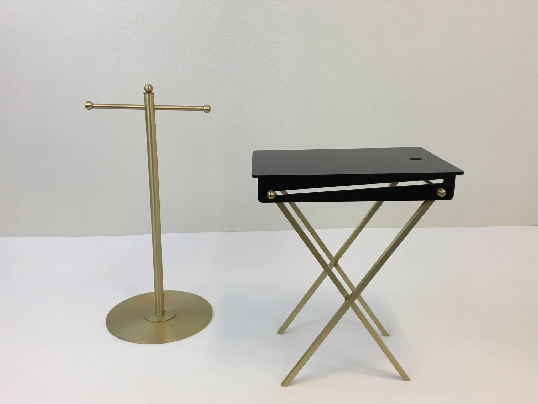 A glamorous set of four brushed brass and black acrylic folding cocktail tables from the 