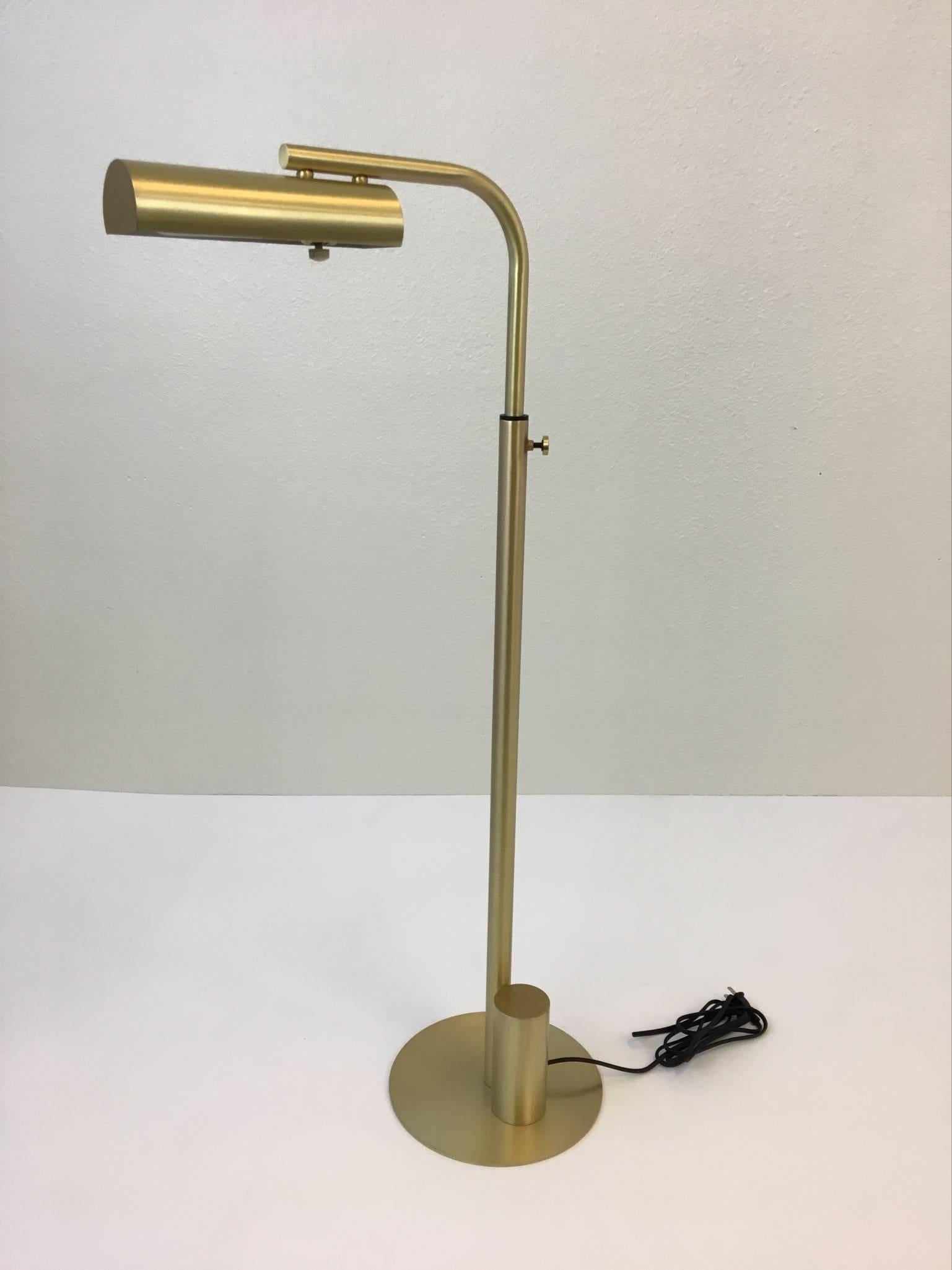 An adjustable satin brass reading floor lamp from the 