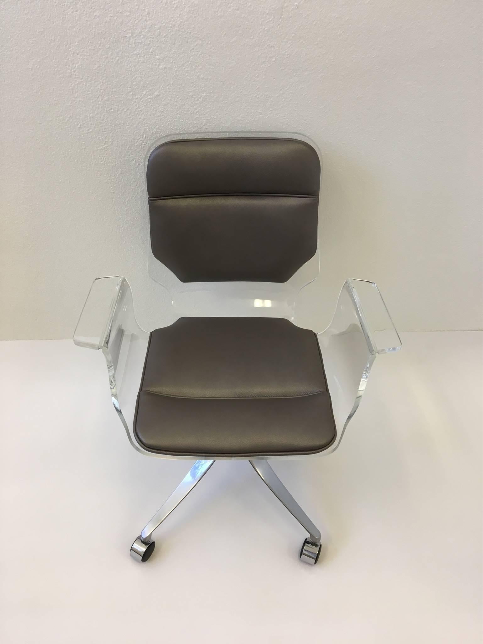 An elegant clear acrylic with polished aluminium base newly reupholstered with a soft grey leather. Made by Hill Manufacturing Co. in the 1970s.

Dimensions: 33.5