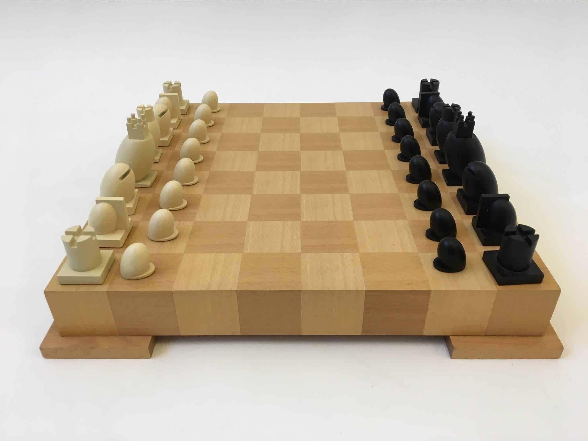 A beautiful sculptural chess and checkers set by Renowned Architect Michael Graves born in 1934 and passed away in 2015. All the chess pieces and board have the Graves signature. 
The chess board is a veneer wood, where you can store the chess