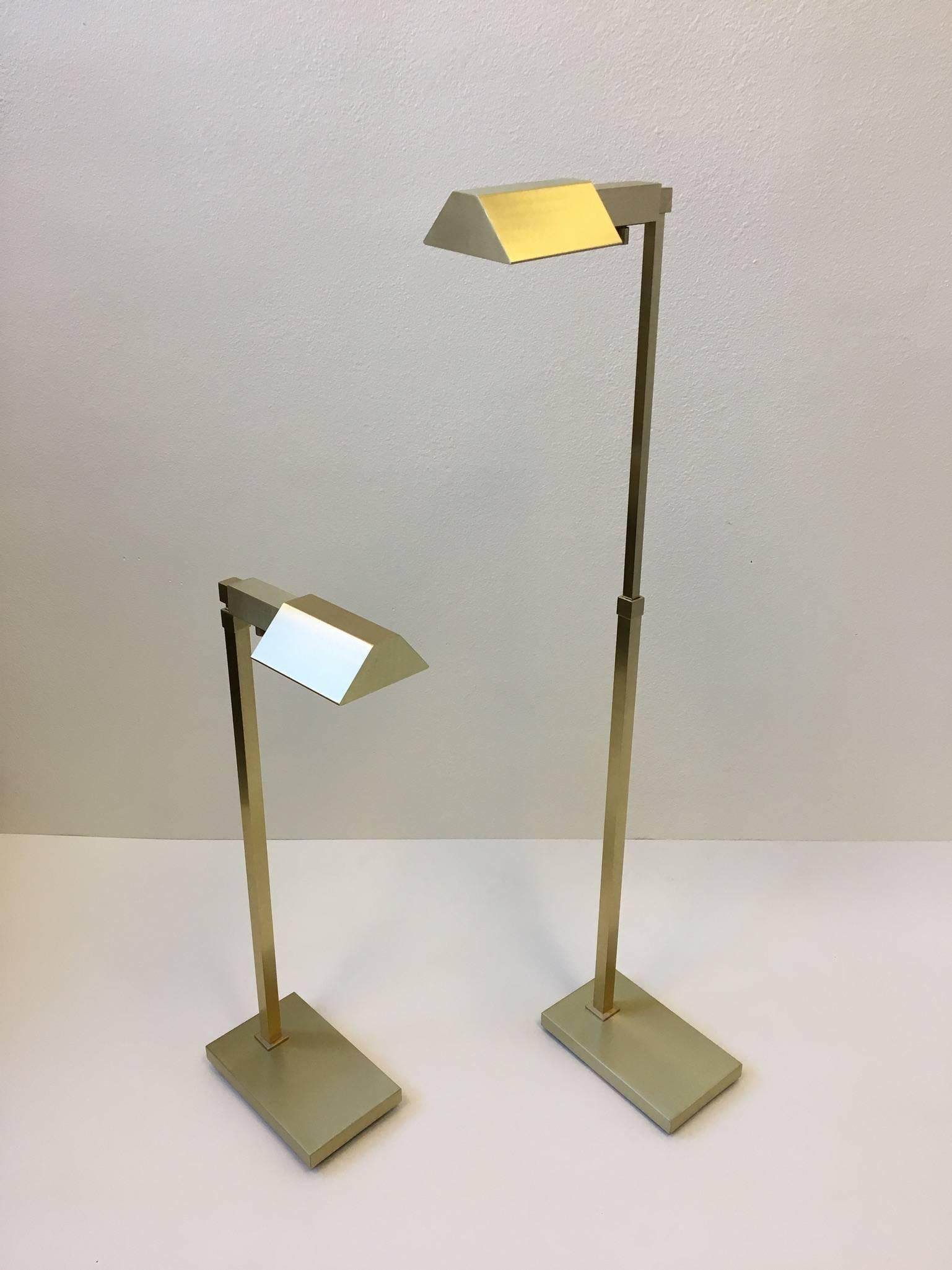 A beautiful pair of adjustable brushed brass floor lamps by Casella. The lamps can be raise and lower. When all the way down the height is 31.5