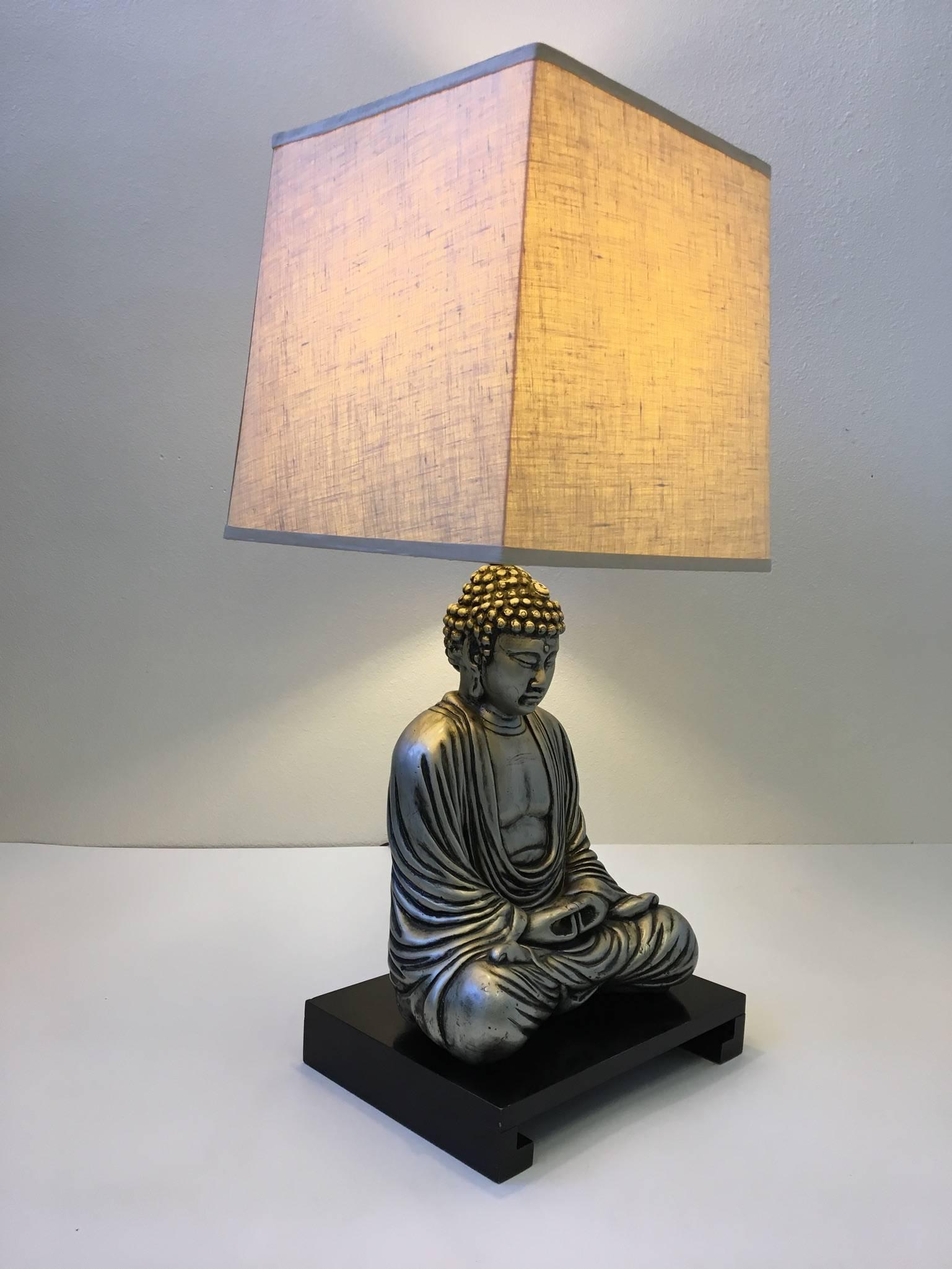 A beautiful silver finished and black lacquered Buddha sculpture table lamp in the manner of James Mont. The lamp has been newly rewired with nickel hardware. The Vanilla linen shade is original.
Dimensions: 36.75