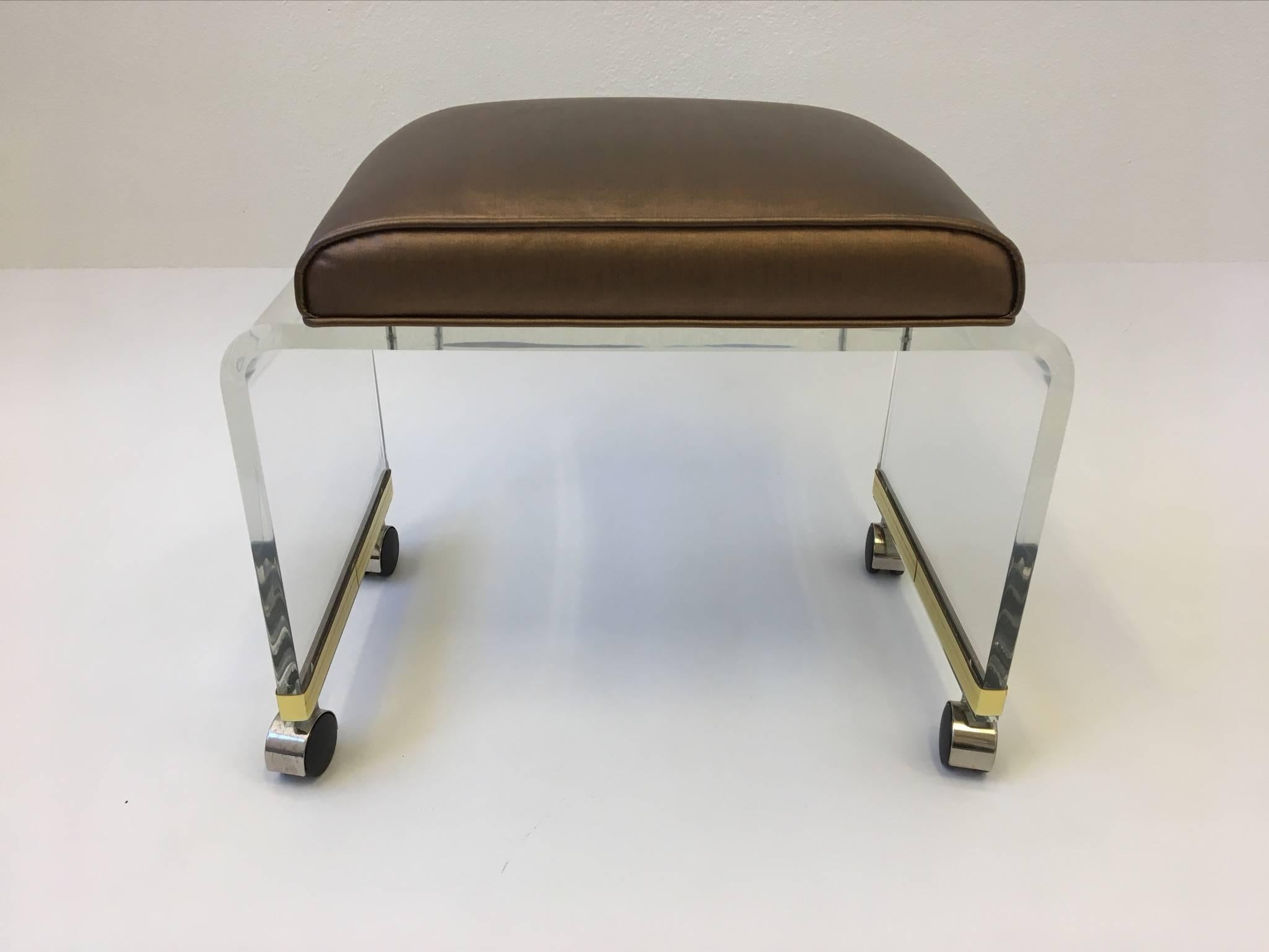 A glamorous 1980s thick acrylic waterfall vanity stool by Hill Manufacturing Corp. This is from the 1980s. The acrylic has been professionally polished and newly reupholstered with a copper color high quality vinyl. 

Dimensions: 21.5