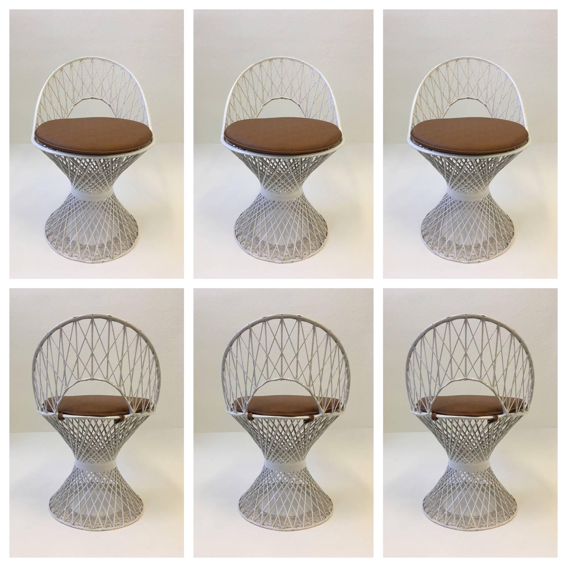 A beautiful set of six spun white fiberglass dining chairs design by Russell Woodard in the 1960s. The chairs have a lite brown faux snake skin Naugahyde seat (please see detail photos). 
Dimensions: 29.75