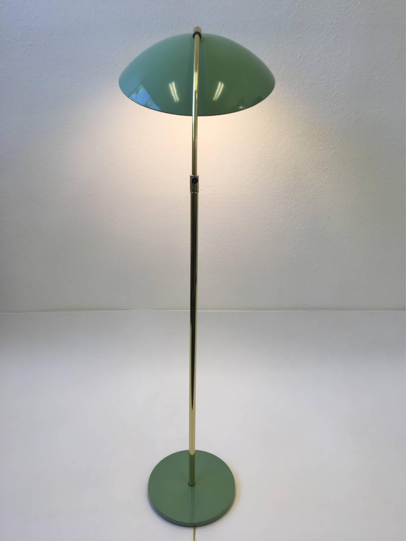 A beautiful adjustable floor lamp designed by Kurt Versen in the 1940s. Newly restored in a fern green lacquer and polished brass. It retains the reflector which most lamps miss. The lamp takes two regular Edison bulbs. The lamp can be rotated. The