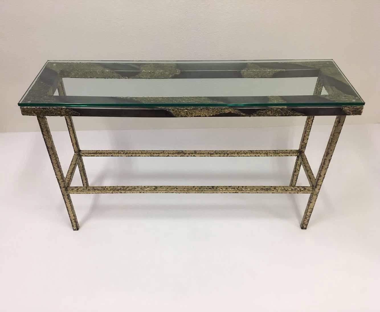 A beautiful studio Brutalist console table designed by American Sculptor John De La Rosa. The table is constructed of steel and brass with a .5 inches thick glass top.
Dimensions: 49 inches wide, 14.5 inches deep, 30 inches high.