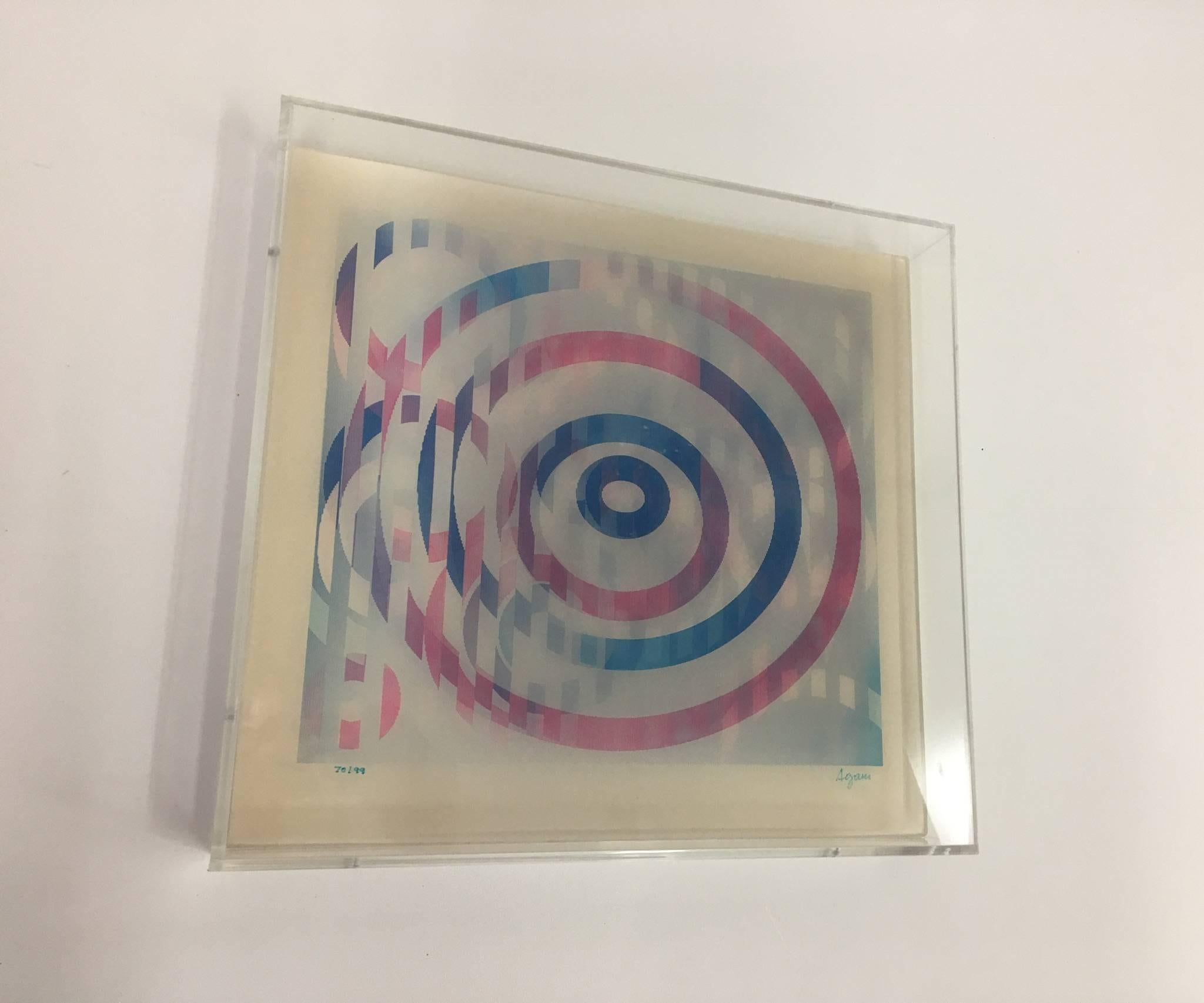 A signed Agam and numbered 70/99 lenticular lightoghraph from the three-piece celebration series from 1990. The image changes depending from where you look at it. Newly framed in a clear acrylic frame. 