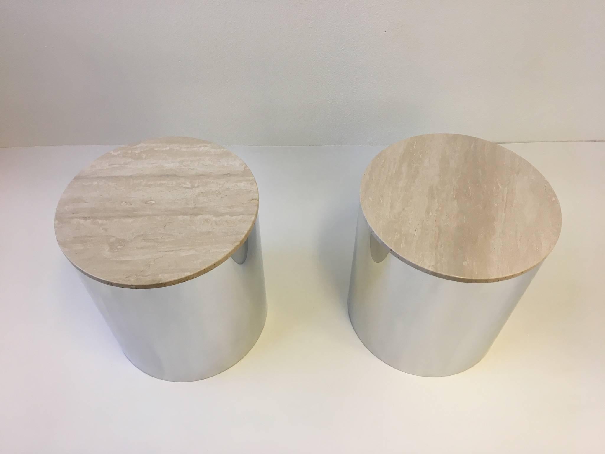 A pair of 1970's polished aluminum drum side tables with Italian Travertine tops design by Paul Mayen for Habitat. The aluminum drums and the travertine tops have been professionally polished. One of the travertine tops have been professionally