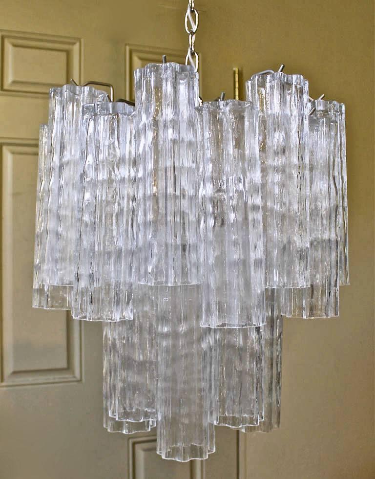 Venini 5 light chandelier composed of thick textured "Tronchi" glass cylinders suspended on a steel frame. These tronchi crystals are an unusual heavy multi-lobed style which interlock to create a very voluminous chandelier. Uses 5 - 40