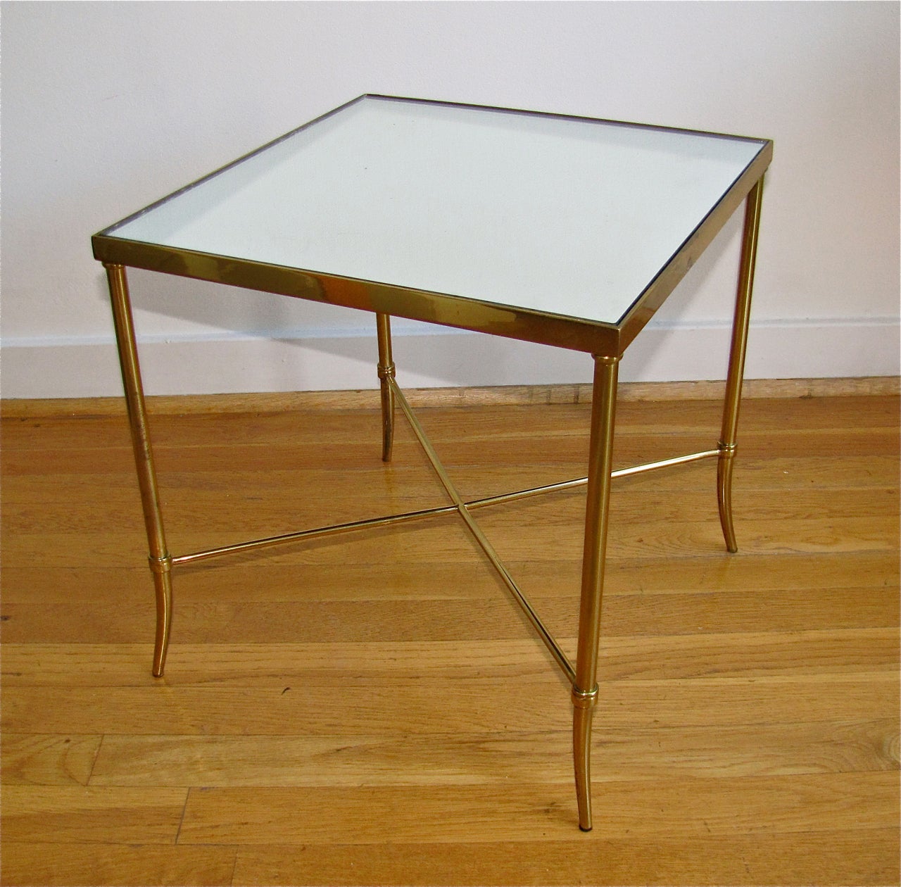 Smaller scale brass side table with x-base stretcher and antique mirror inset top.