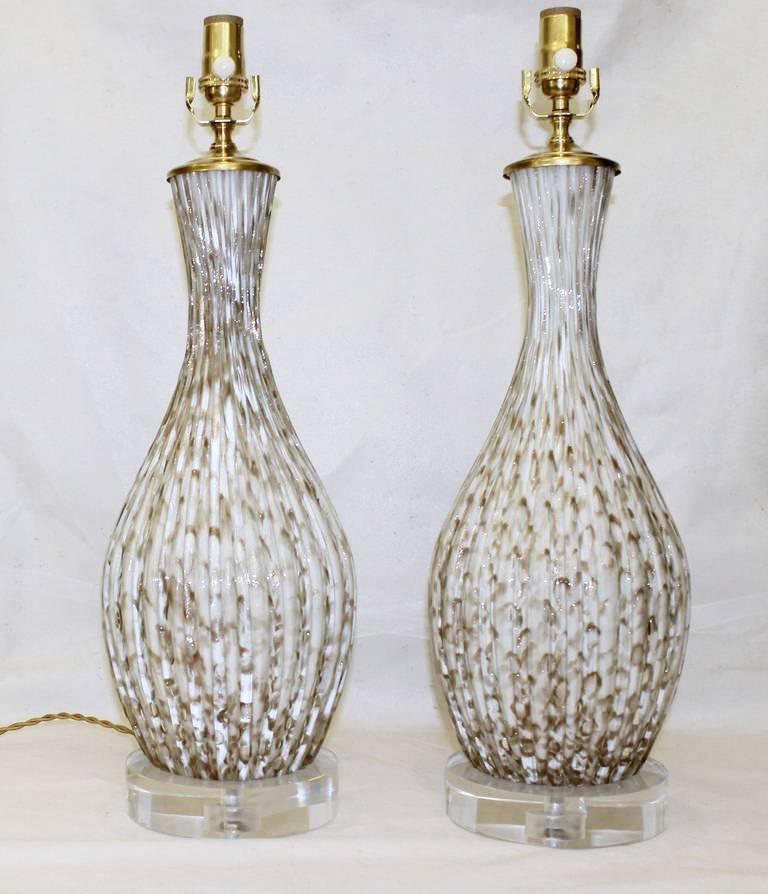 Pair of Italian Murano blown glass table lamps constructed from thick ribs of clear glass encasing white glass with in control bubbles and aventurine flecking throughout in single gourd form. Larger size, but not over scale. Newly wired for US on