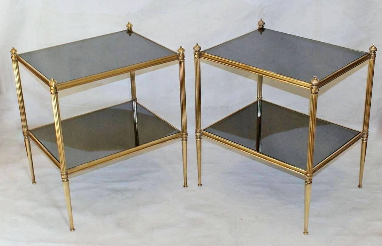 Pair of French two-tier brass end or side tables with newer dark graphite color mirrored inset tops. Nicely detailed brass fittings and a warm patina to brass.

Measure: 19