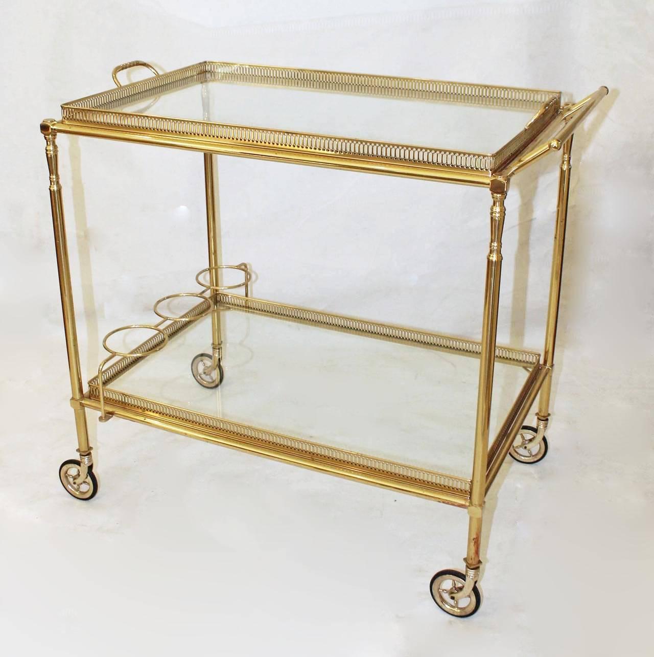 Beautiful French 2 tier brass bar cart with removable trays and glass inset tops and bottle holder. Nice detailing including brass wheels. Pristine condition and a very high quality piece.